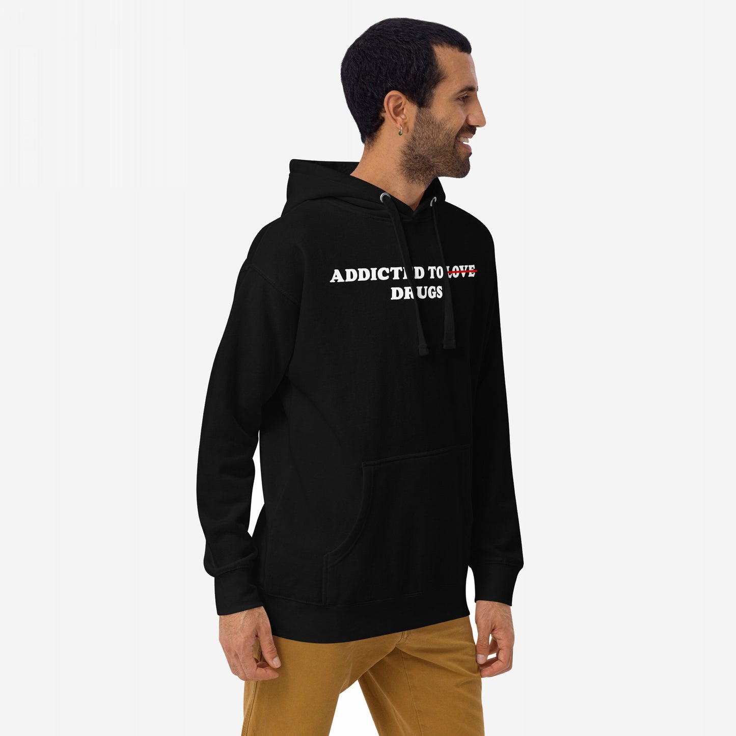 Man in Addicted To Love / Drugs Hoodie, featuring Love crossed out to highlight Addicted To Drugs. Paired with tan pants, the outfit conveys raw self-awareness and street-ready style.