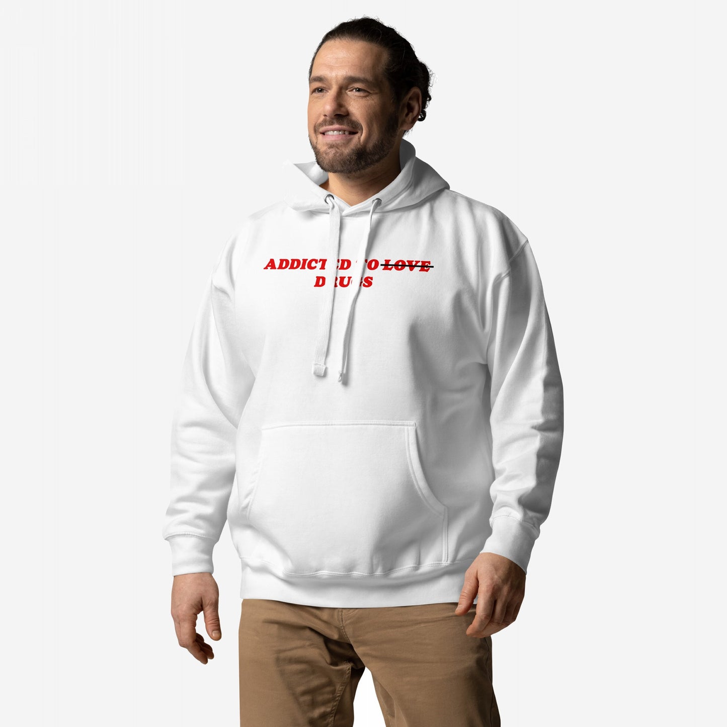 Man wearing Addicted To Love / Drugs Hoodie & Sweatshirt, featuring red strike-through text on a white hoodie. Pairs with tan pants, embodying a message of personal struggle and self-awareness.