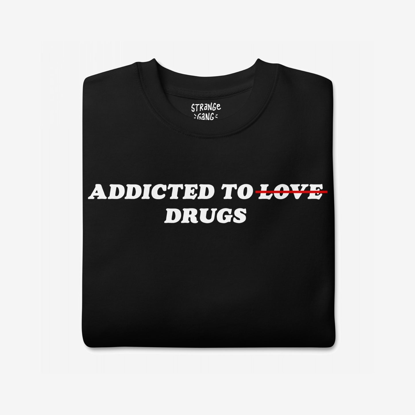Folded black T-shirt featuring Addicted To Love / Drugs design with LOVE crossed out in red, replaced by DRUGS underneath. A bold statement piece reflecting personal struggle and self-awareness.