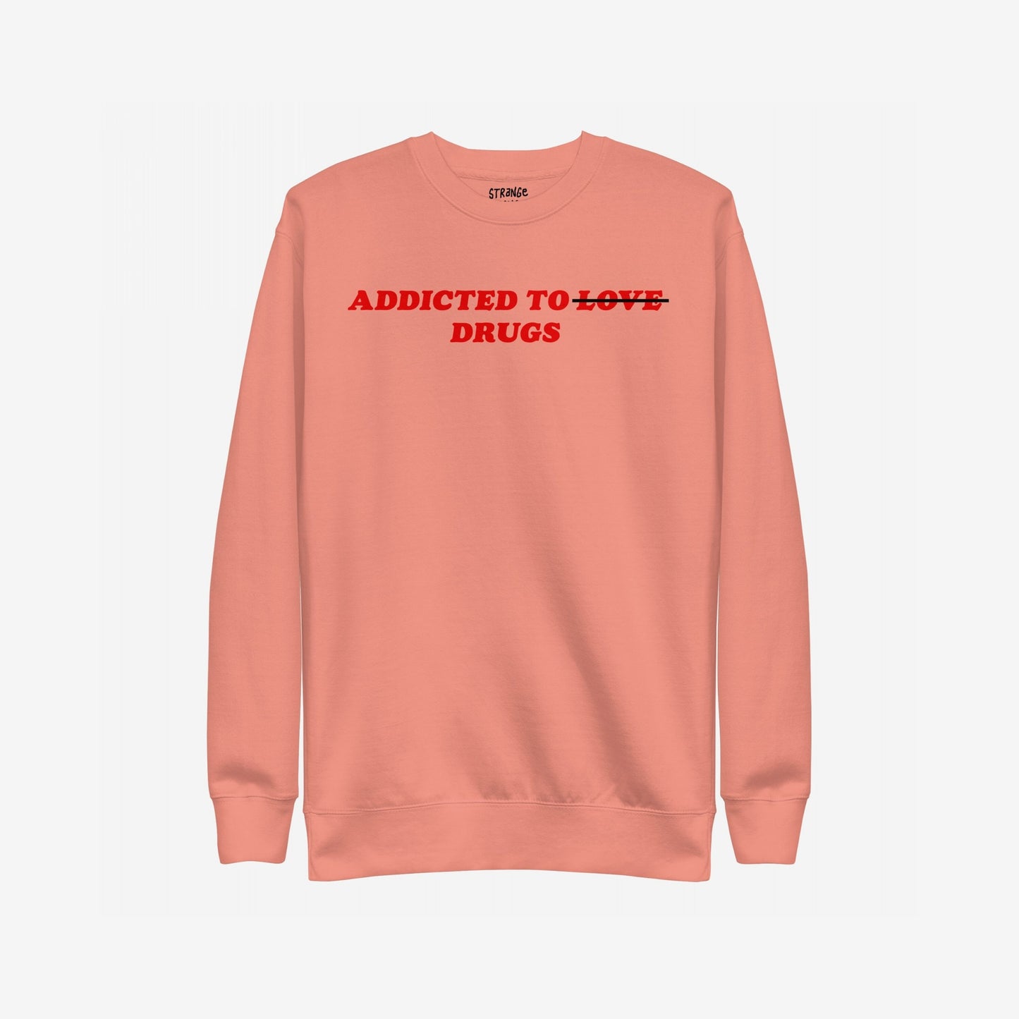Muted coral crew-neck sweatshirt with bold red text: Addicted to ̶L̶O̶V̶E̶ DRUGS. LOVE is crossed out, symbolizing a raw, honest twist on classic themes.