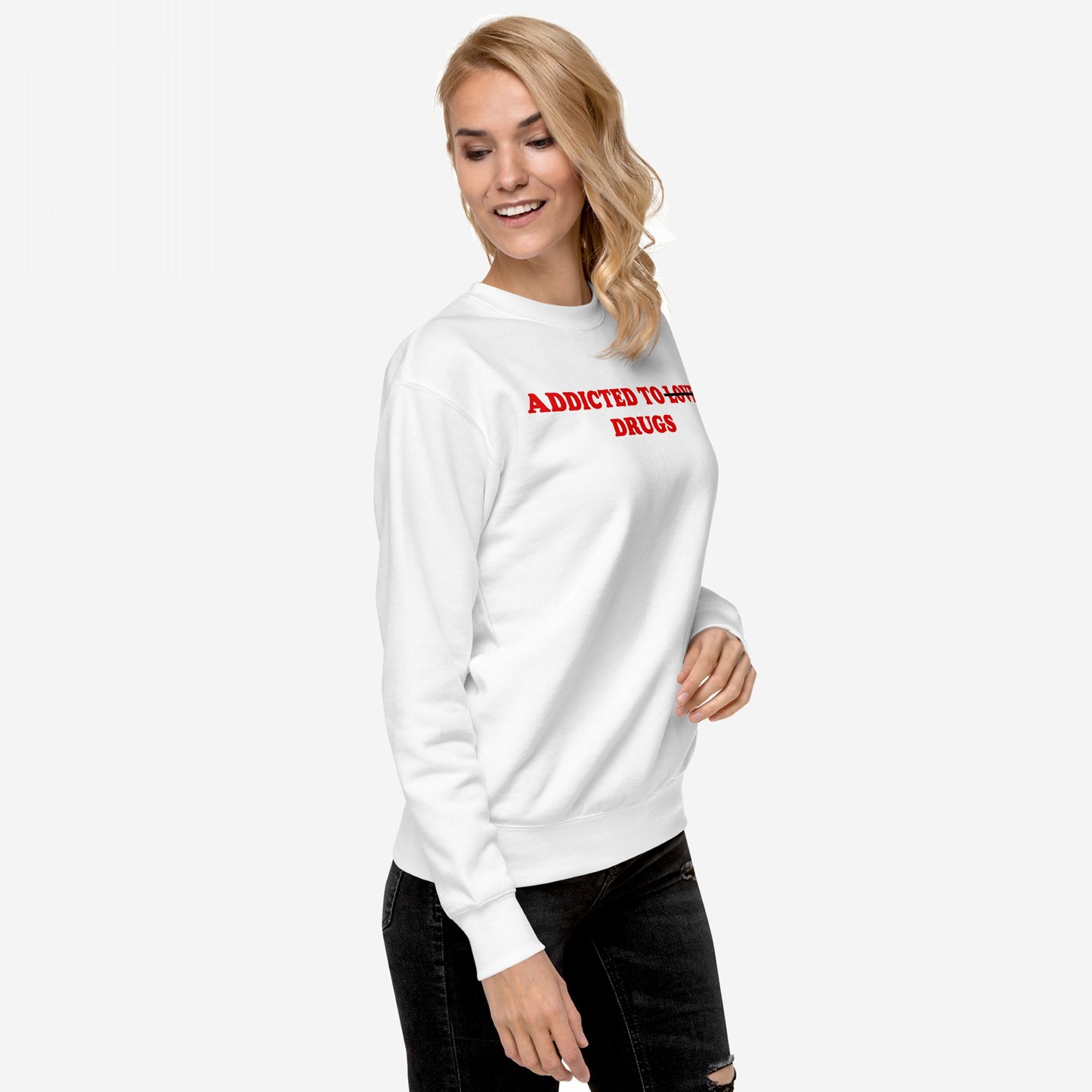 Young woman wears Addicted To Love / Drugs sweatshirt with bold red text, pairing it with dark, ripped jeans. This piece embodies raw expression and self-awareness, resonating with personal struggle and honest vibes.