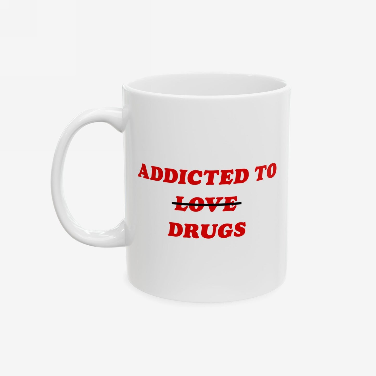 White ceramic Addicted to Love / Drugs Mug features bold red text with LOVE struck out, replaced by DRUGS. Captures humor and mental health themes, perfect for coffee breaks.