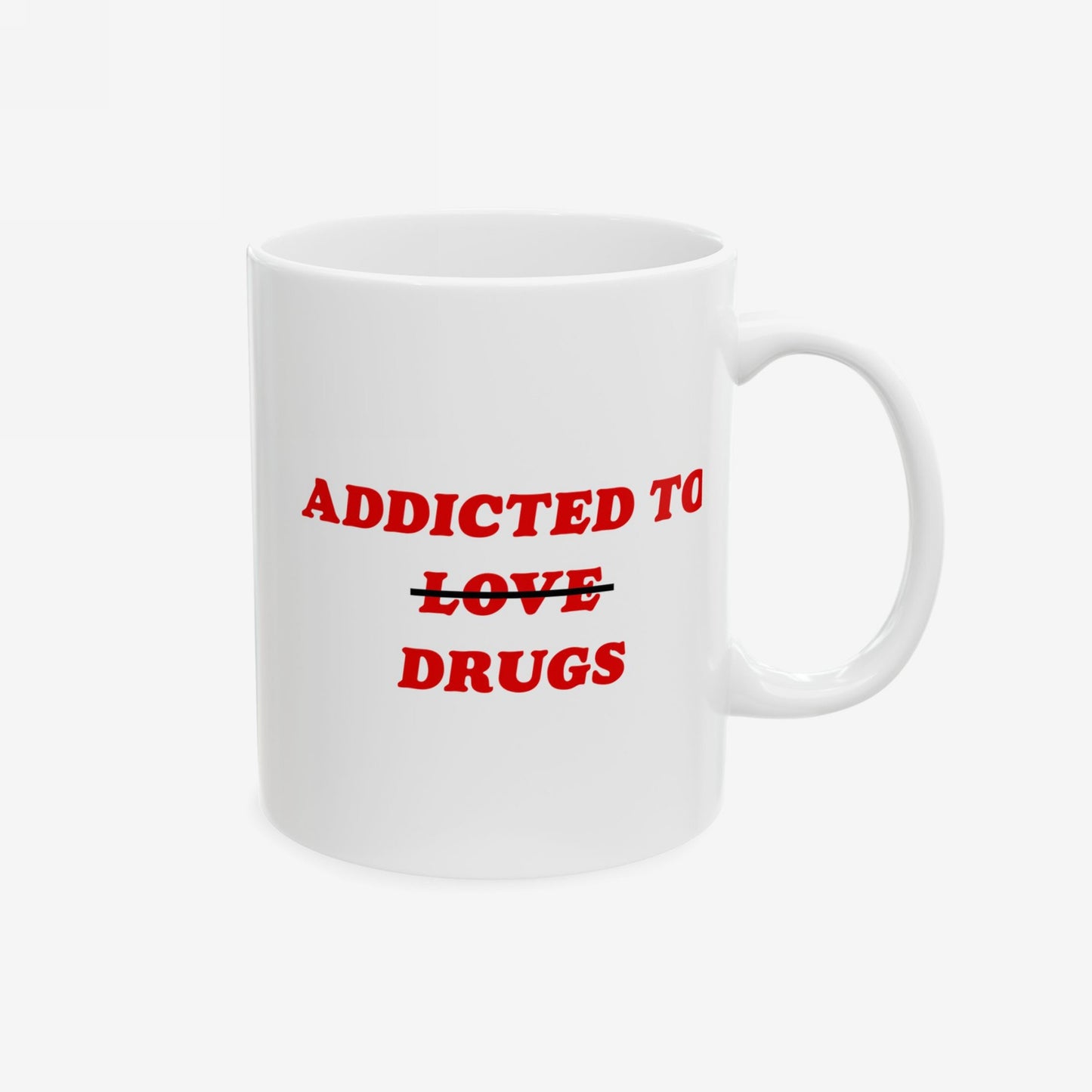 White ceramic mug with bold red text reading “ADDICTED TO” with “LOVE” crossed out, followed by “DRUGS.” A humorous take on mental health. Available in 11 oz. and 15 oz. sizes.