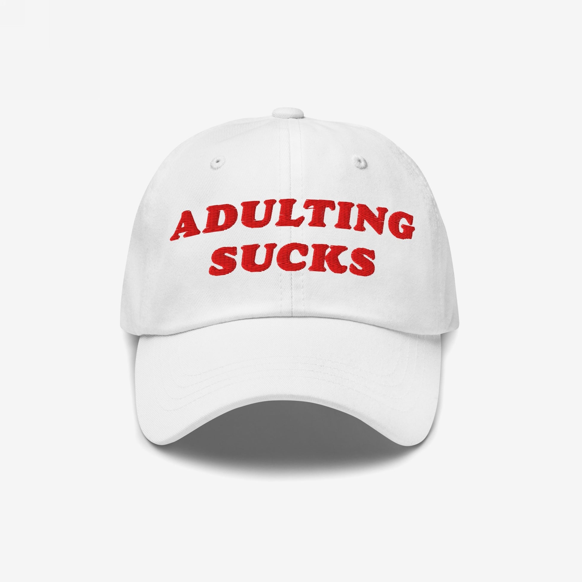 Adulting Sucks Hat with red embroidered lettering on a white cap, expressing relatable frustration with adulthood. Ideal for millennials and Gen Z, reflecting a bold statement on adult responsibilities.