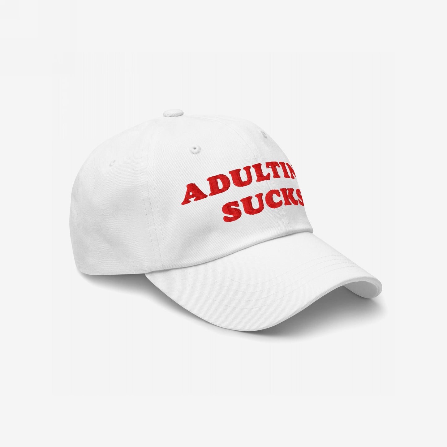 Adulting Sucks Hat featuring bold red embroidery on a white, six-panel baseball cap, expressing a relatable message for the overworked, embodying a candid and vintage-style statement on life's challenges.