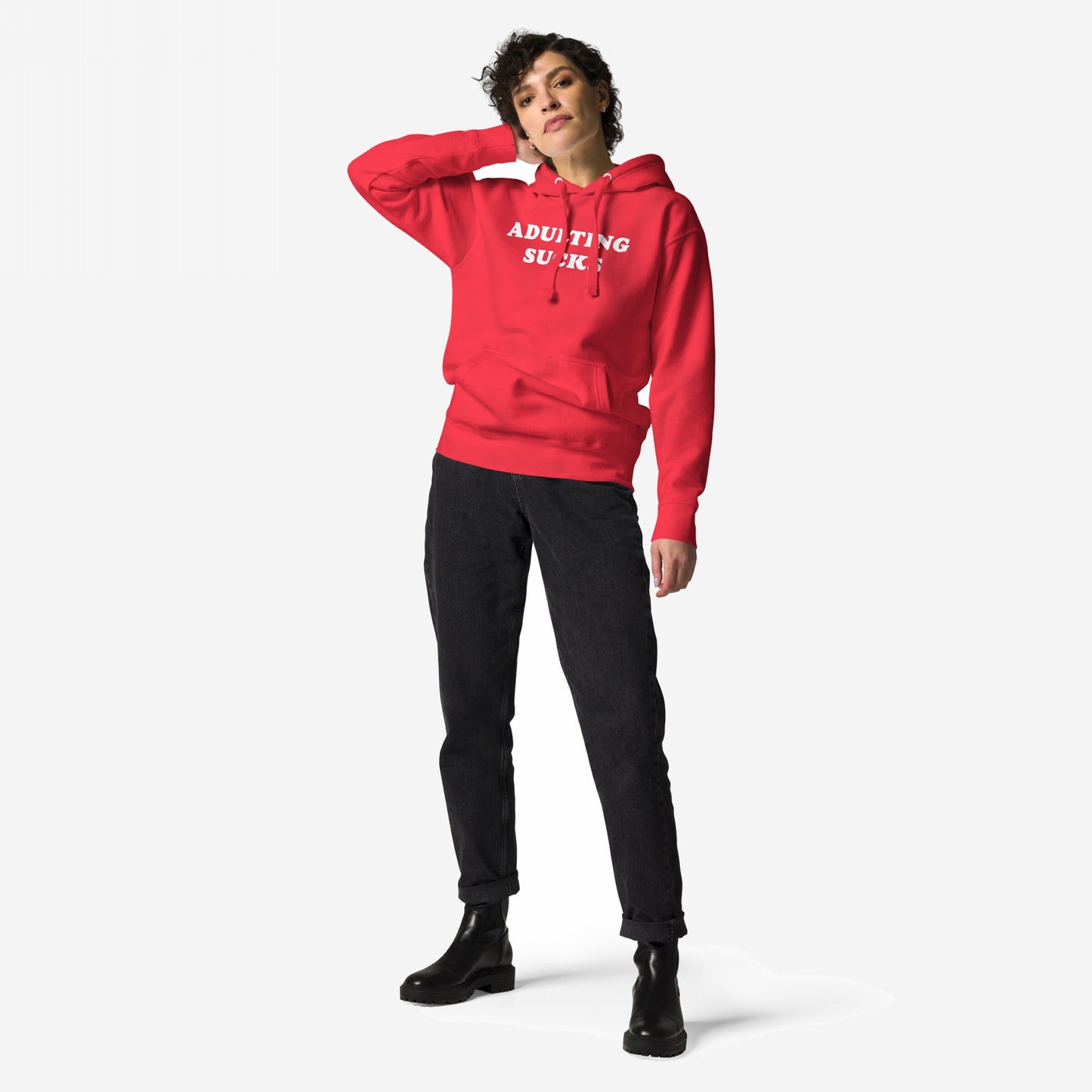 Person modeling the Adulting Sucks Hoodie & Sweatshirt with ADULTING SUCKS printed in white, showcasing its comfort and relatable humor. Paired with black jeans and boots, capturing a laid-back style.