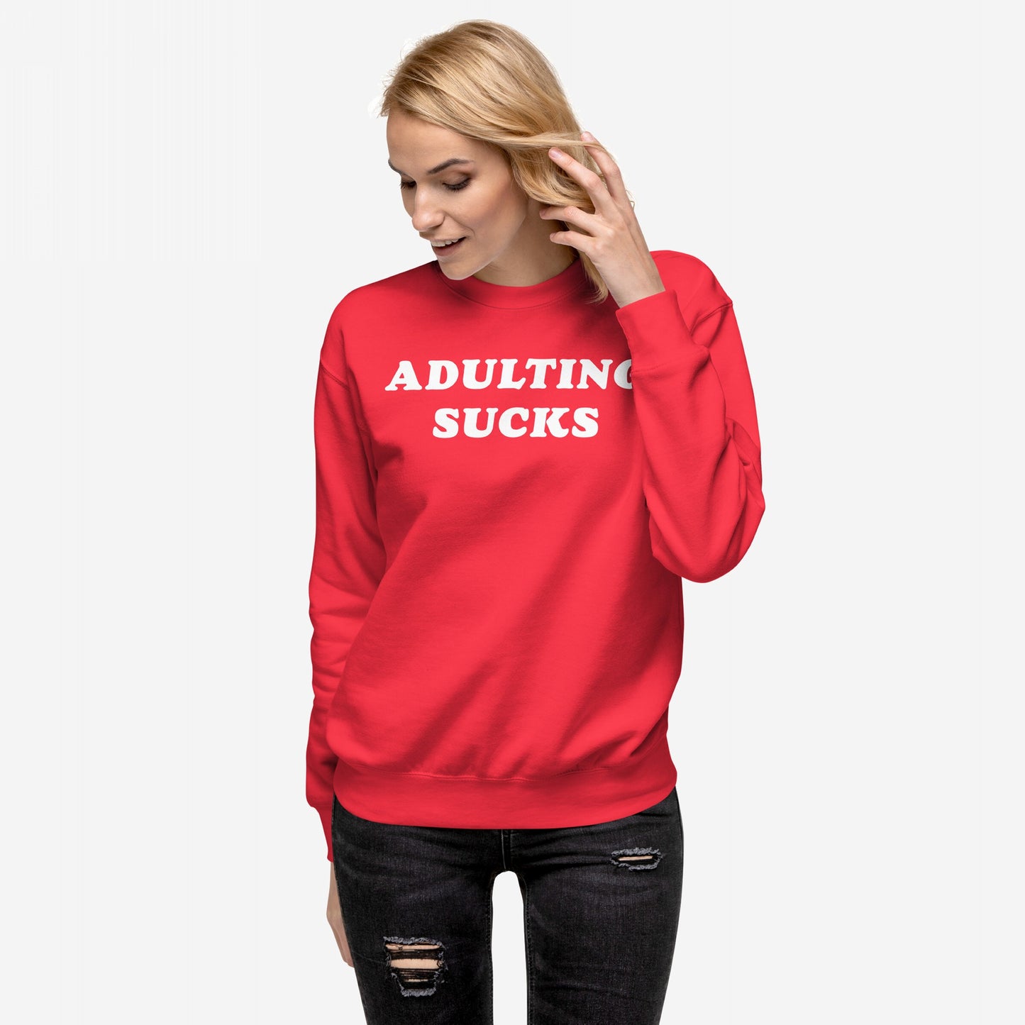 Young woman wearing the Adulting Sucks Hoodie & Sweatshirt, featuring bold ADULTING SUCKS text. She styles it with black ripped jeans, embodying humor and honesty in retro-fleece fashion.