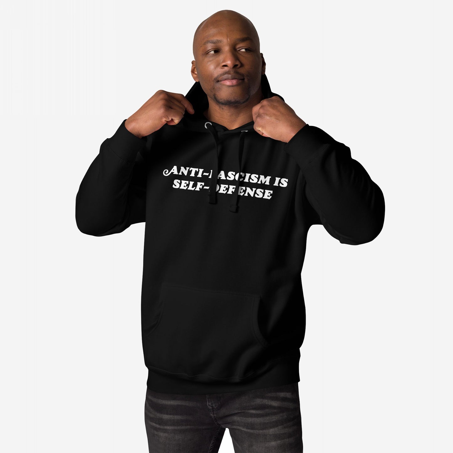 Man adjusting hood on the Anti-Fascism Is Self-Defense Hoodie & Sweatshirt, showcasing bold white slogan across chest, embodying a clear message of resistance and empowerment.