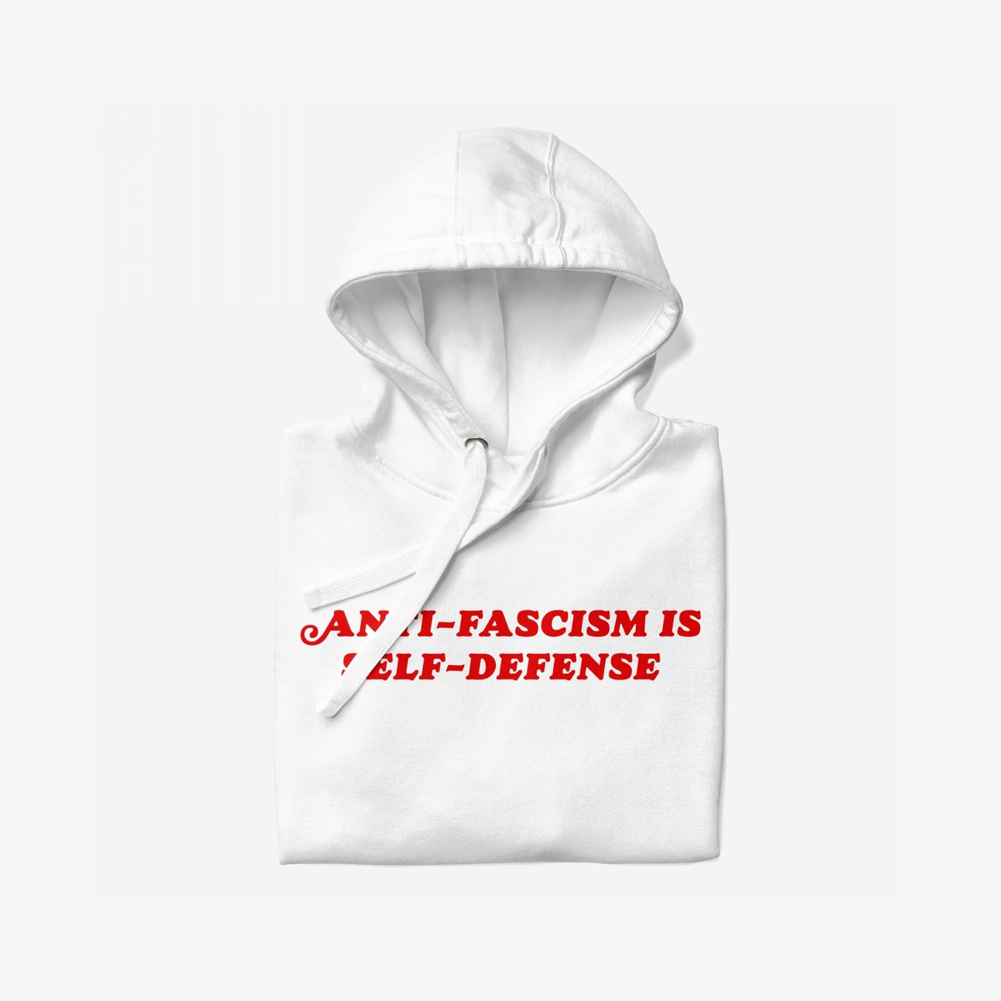 Anti-Fascism Is Self-Defense Hoodie, featuring bold red text on the front. The white hoodie is folded with its hood up and drawstring visible, embodying a strong, confrontational message.
