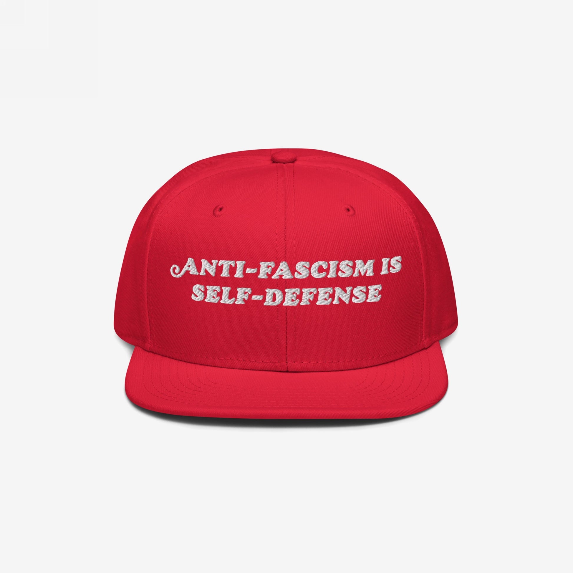 Bright red snapback cap with “ANTI-FASCISM IS SELF-DEFENSE” embroidered in white, embodying activist spirit. Ideal for rallies, supporting ACLU, and promoting equality.
