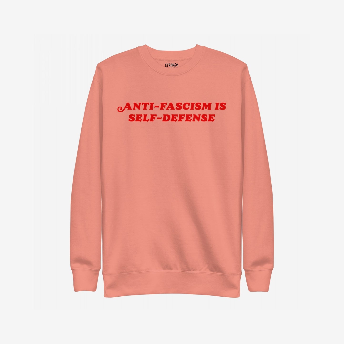 Coral-pink crewneck sweatshirt with bold red ANTI-FASCISM IS SELF-DEFENSE text across the chest, embodying the Anti-Fascism Is Self-Defense Hoodie & Sweatshirt's message of resistance and solidarity.