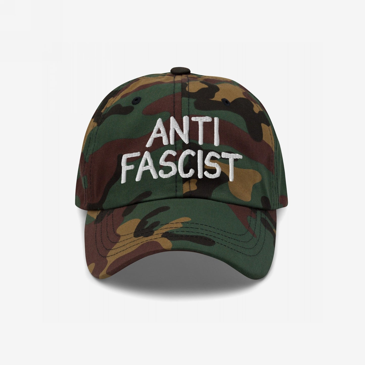 Anti-Fascist Hat with camouflage pattern and white ANTI FASCIST embroidery. Features six-panel design with ventilation eyelets and curved brim, embodying a bold yet subtle protest statement.
