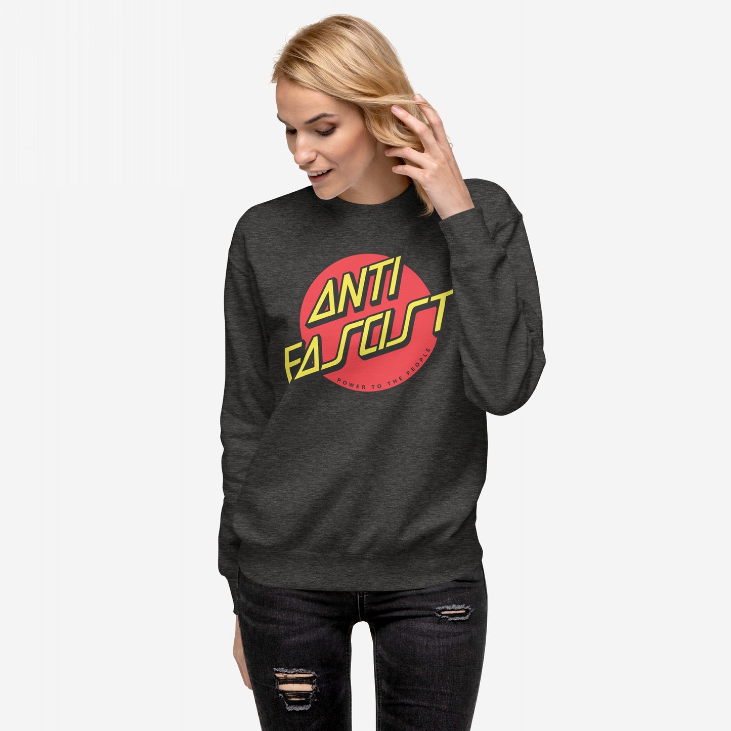 Young woman in a dark gray Anti-Fascist Hoodie & Sweatshirt with ANTI FASCIST and POWER TO THE PEOPLE graphic, embodying skate and street-punk style, wearing black distressed jeans.