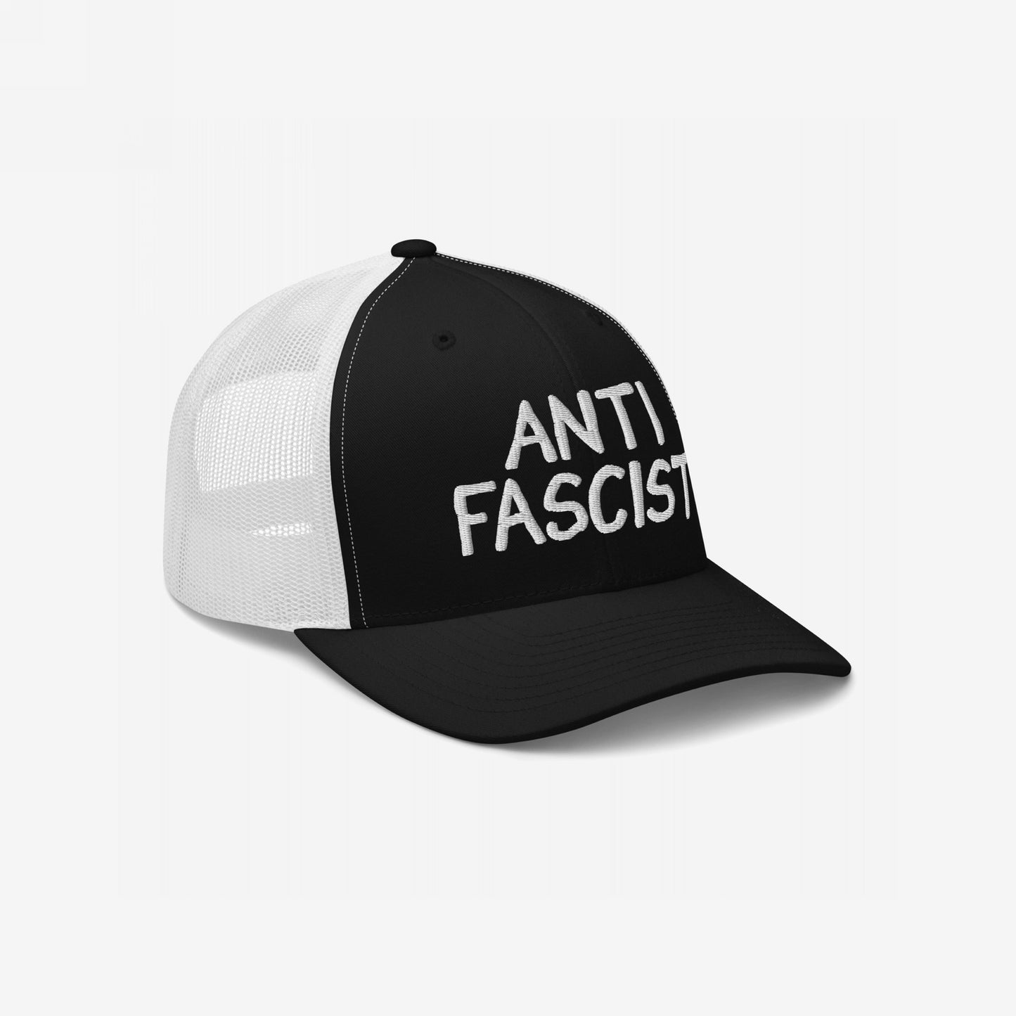 The Anti-Fascist Hat features a black front with bold white ANTI FASCIST embroidery, contrasting with a white mesh back, symbolizing a stylish stand against oppression.