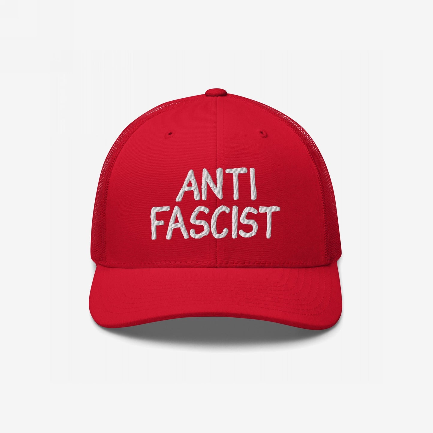 Red mesh-back trucker hat with white embroidered ANTI FASCIST lettering, embodying a bold yet understated protest style, ethically crafted for daily wear supporting equality and anti-fascism.