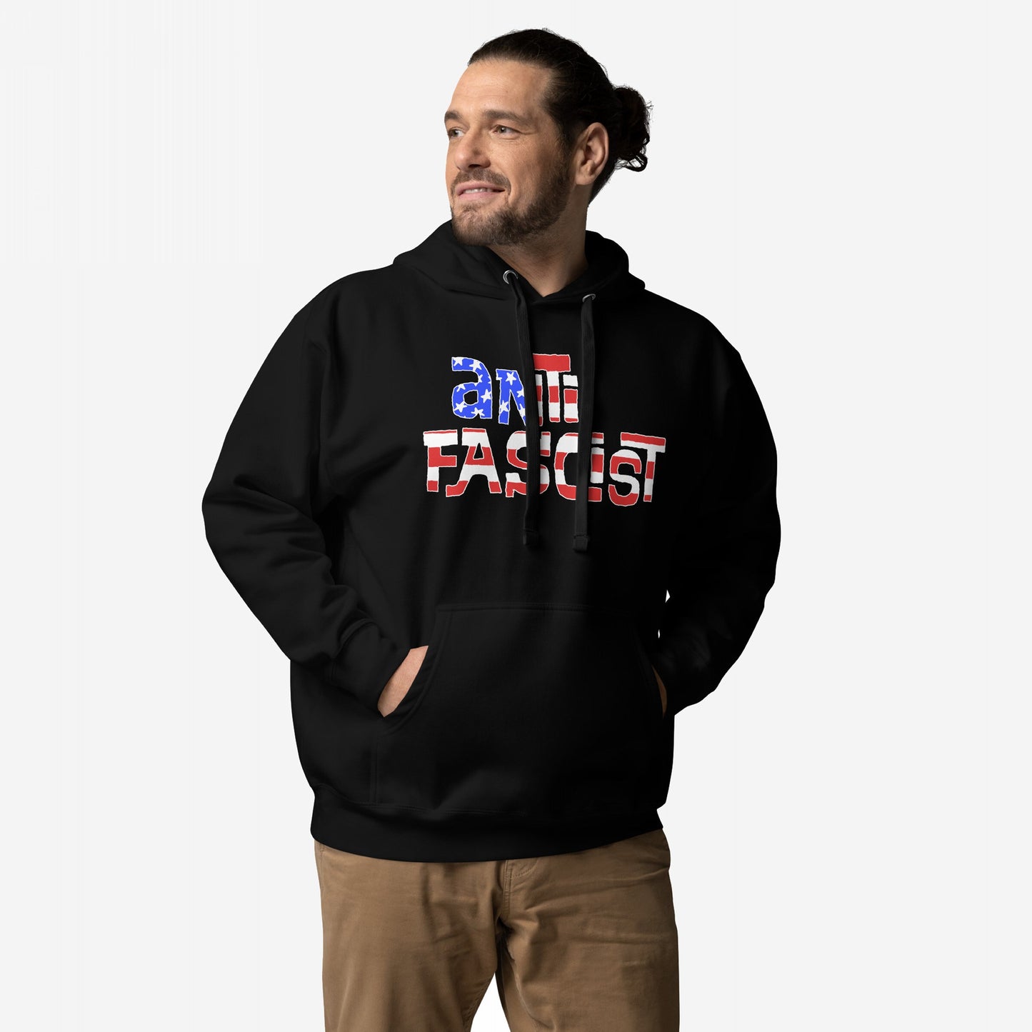 Man wearing Anti-Fascist USA Hoodie, featuring a ANTI FASCIST slogan in star-and-stripe design, hands in front pocket, paired with tan pants. Highlights patriotic resistance and activism.