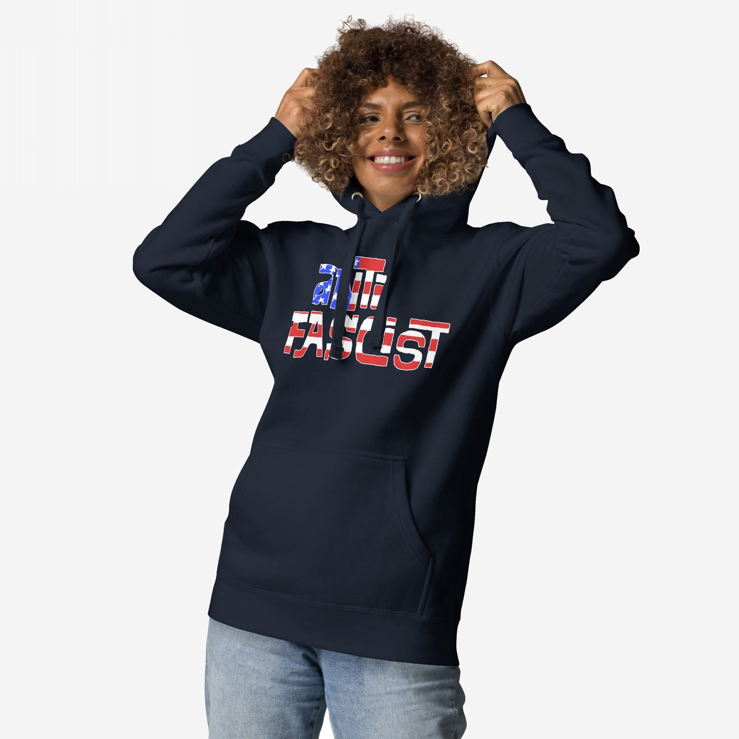 Model smiling while wearing the Anti-Fascist USA Hoodie, featuring a stars-and-stripes slogan. This fleece embodies resistance and patriotism, perfect for showing your stance against hate and supporting equality.