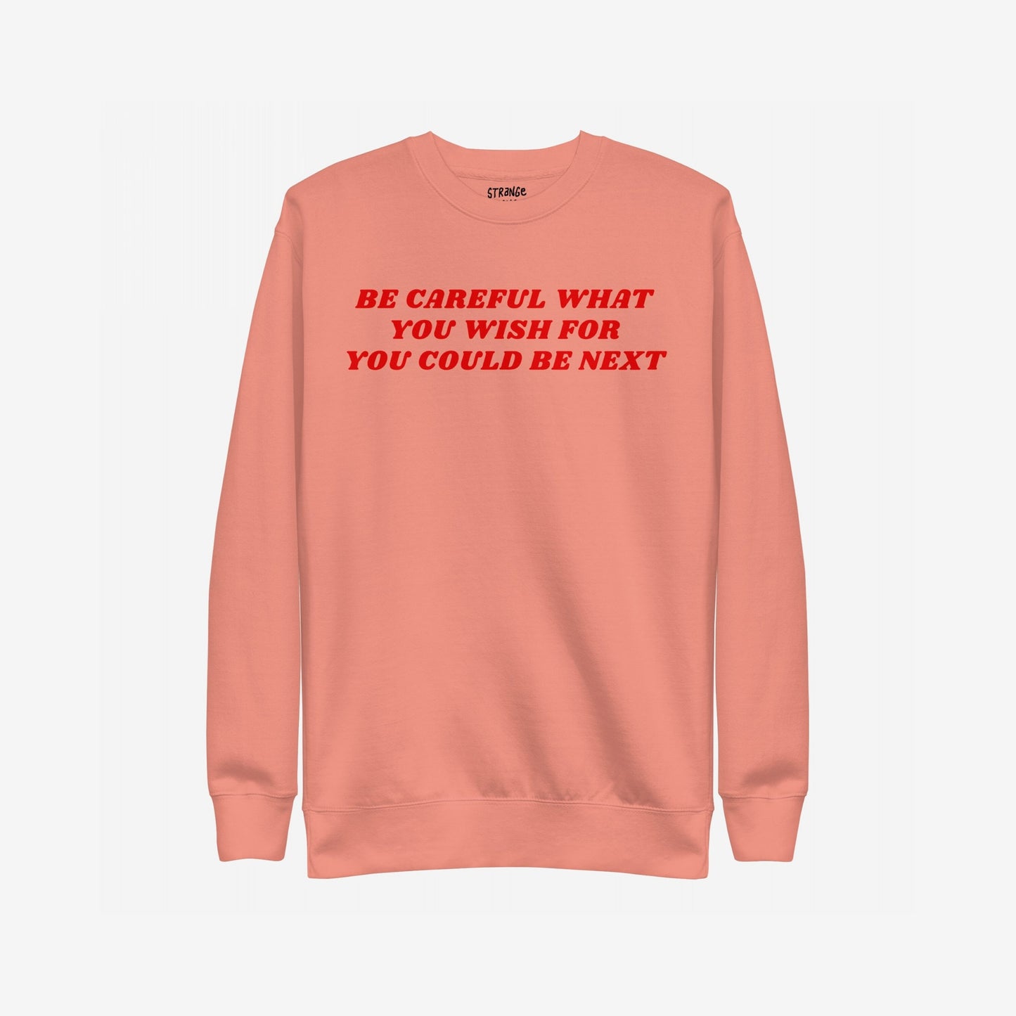 Be Careful Hoodie & Sweatshirt featuring bold red warning text on salmon crewneck, conveying modern rebellion and resistance against authoritarianism. Label inside reads 'STRΛNGE.' Perfect for making a strong statement.