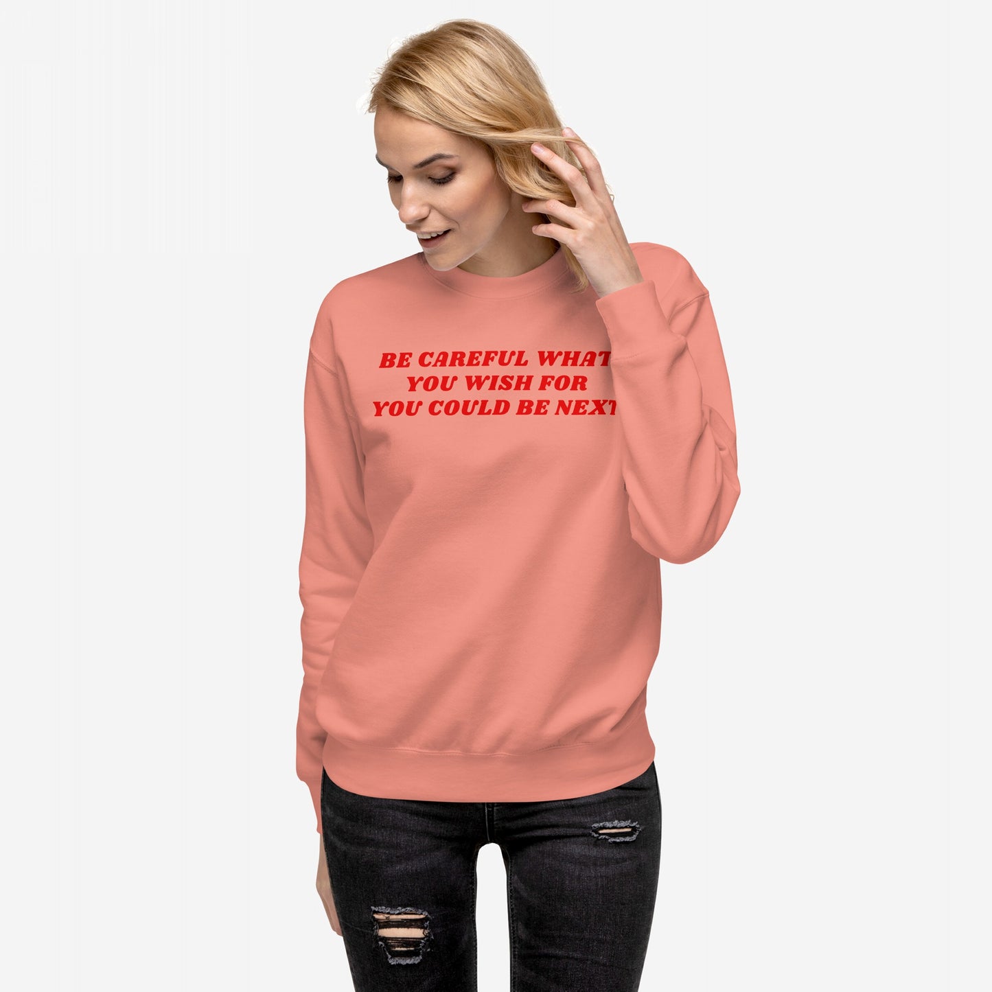 Young woman models the Be Careful Hoodie & Sweatshirt, featuring bold red text warning against authoritarianism, paired with black ripped jeans, embodying modern rebellion with a Y2K flair.