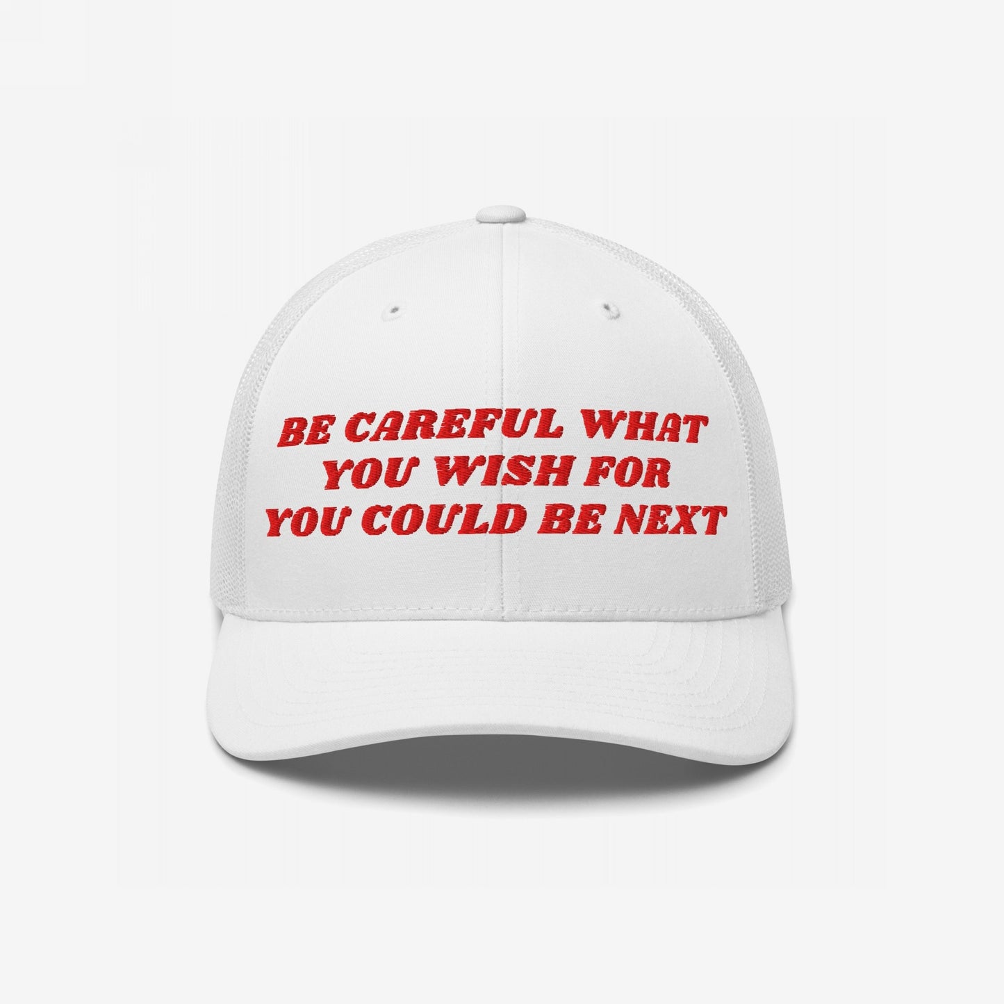 White baseball cap with red embroidery reading Be Careful What You Wish For / You Could Be Next, echoing a bold message of caution and empowerment.