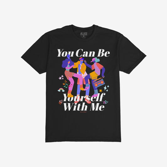 The Be Yourself Shirt features a vibrant illustration of three dancers, one with a boombox, surrounded by stars, hearts, music notes, and a rainbow, promoting individuality and support.
