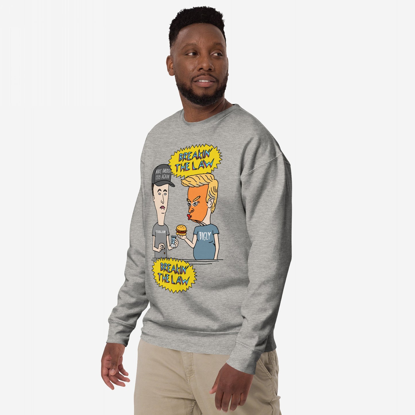 Breakin' The Law Sweatshirt featuring a cartoon parody of figures resembling Trump and Musk, styled like Beavis and Butt-Head, with satirical captions, embodying an anti-elitist, rebellious spirit.