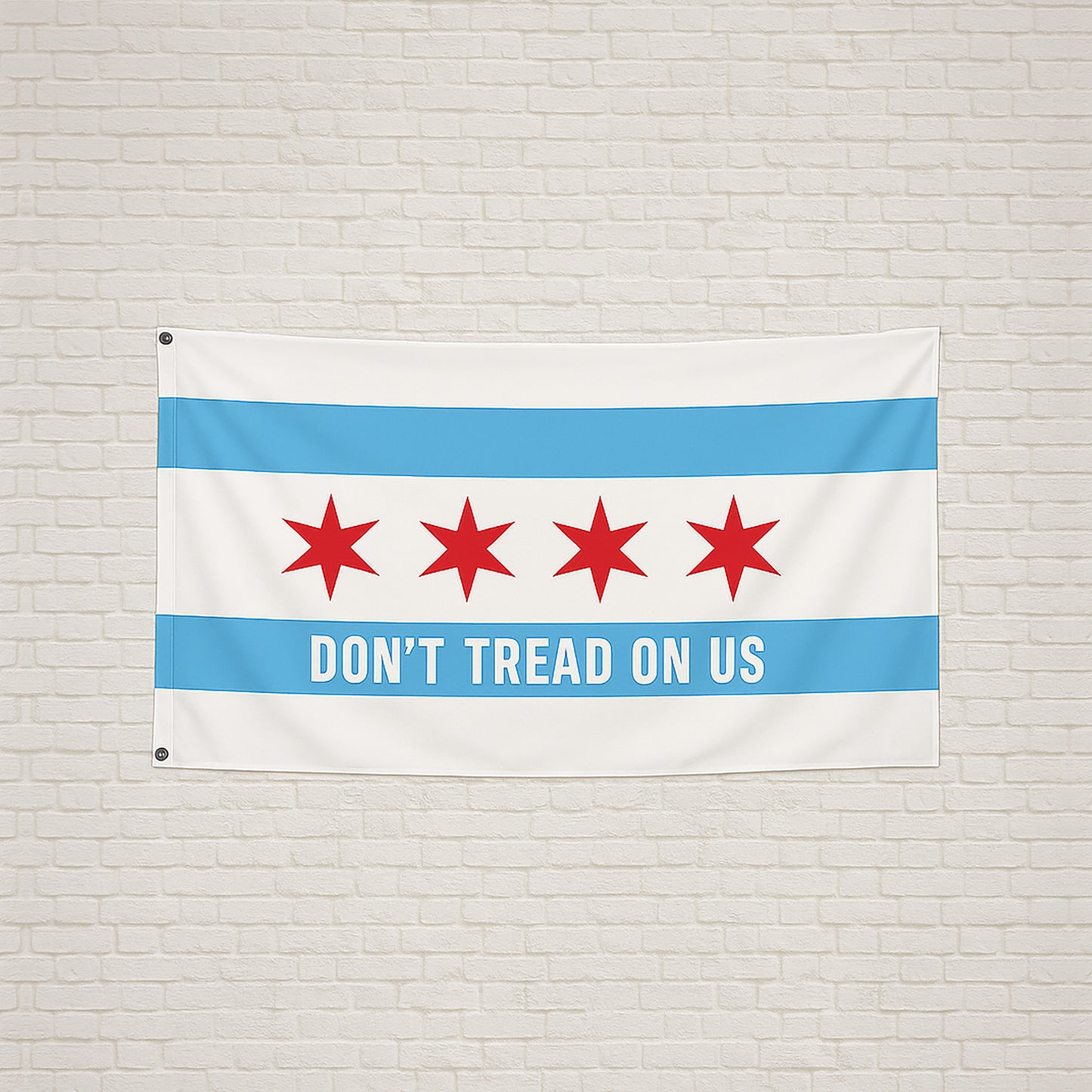 Chicago Gadsden Flag hanging on a light brick wall, featuring Chicago's stars and text DON’T TREAD ON US on a sky-blue stripe, symbolizing protest and resistance.