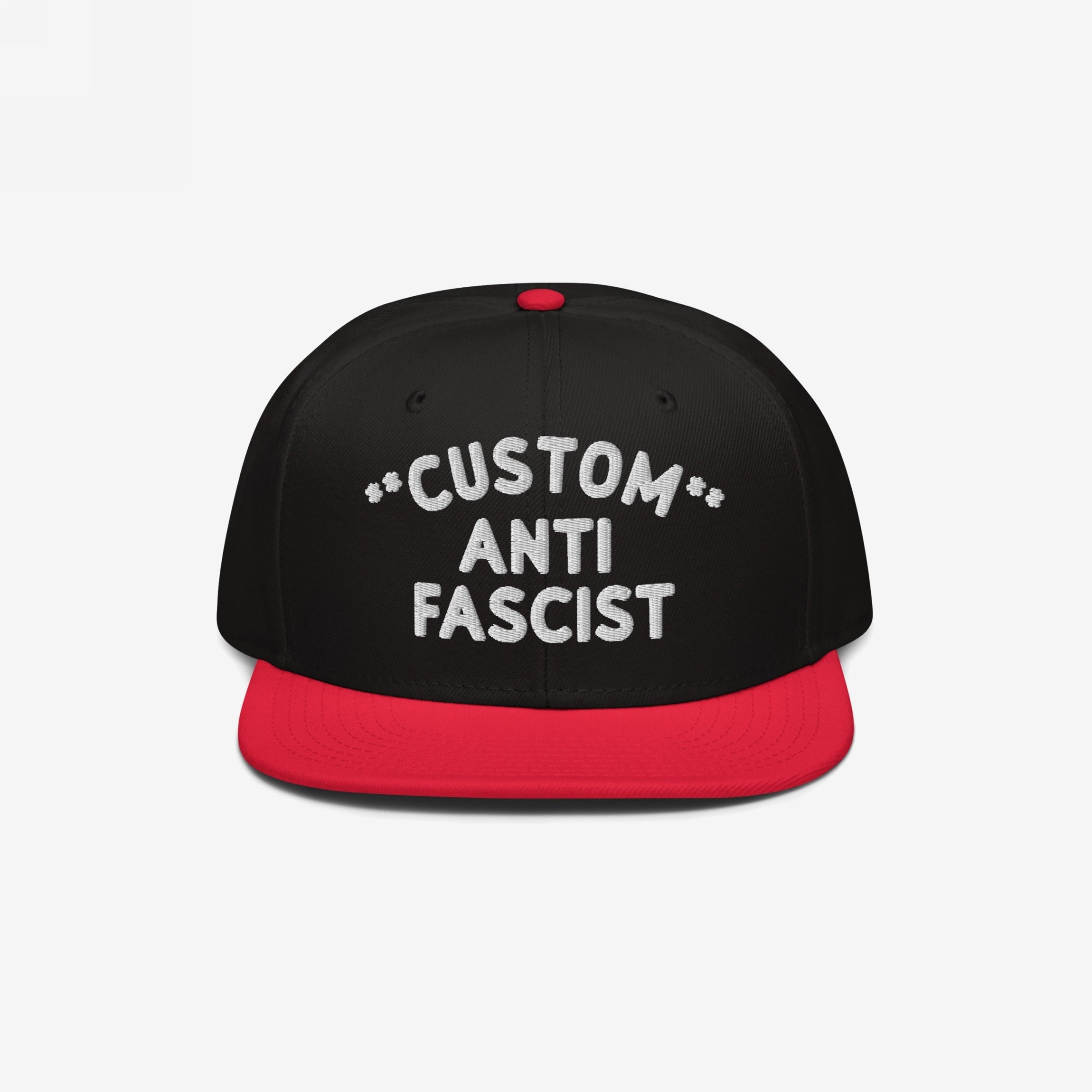 Custom Anti-Fascist Snapback Hat with black crown and red brim, featuring bold white embroidered text CUSTOM ANTI FASCIST on the front panel. Ideal for expressing activism and personalized messaging.