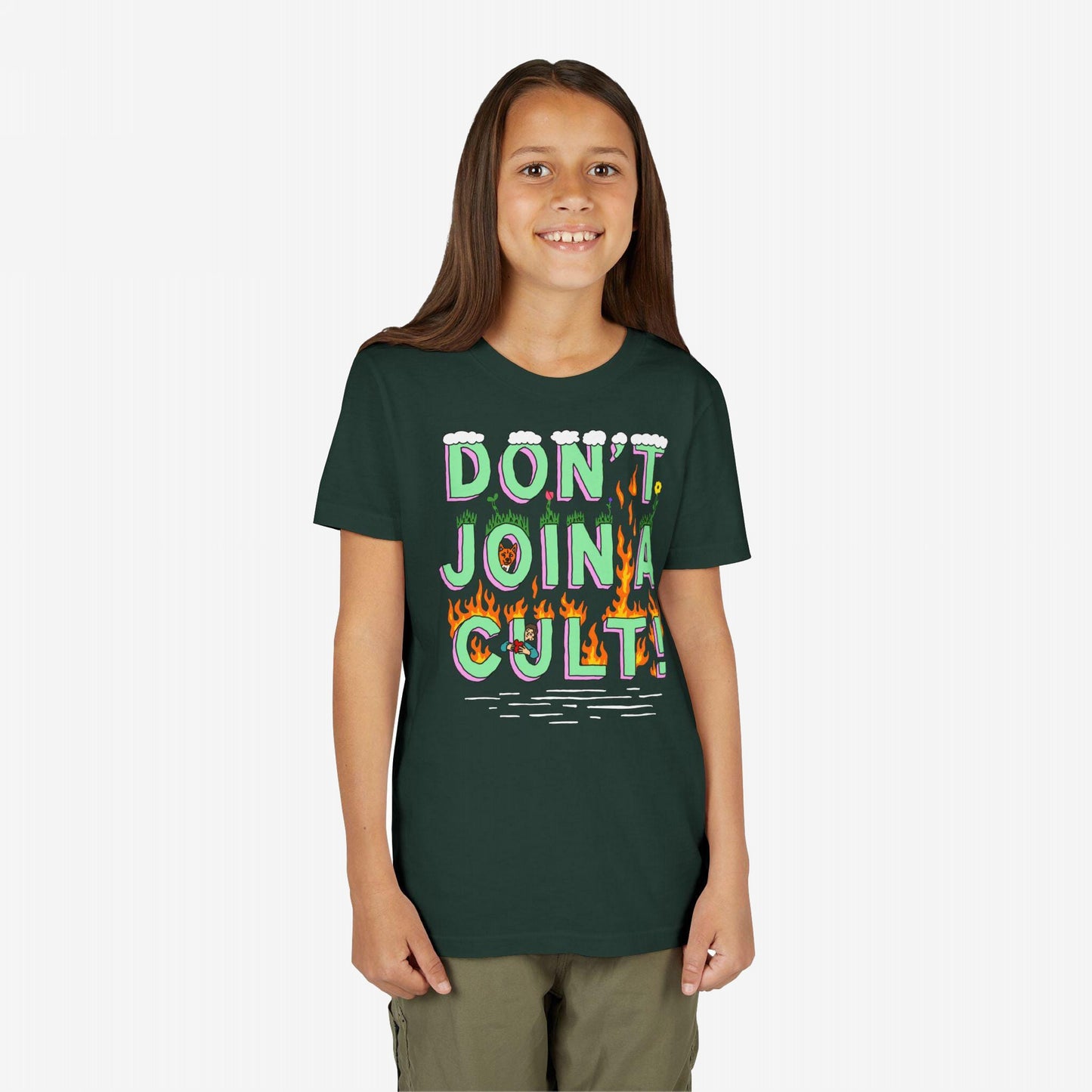 Young girl smiling, wearing the Don't Join A Cult T-shirt with colorful lettering, grass patches, and flames, embodying a bold, progressive message. Arms relaxed, perfect for rallying or casual wear.