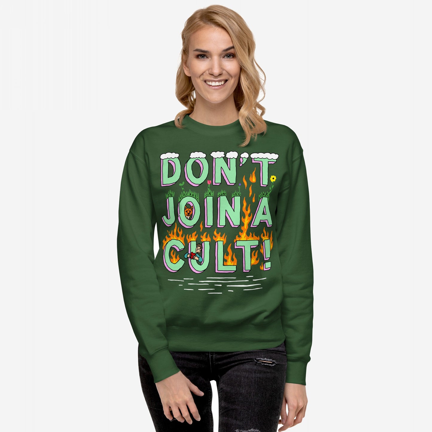Don't Join A Cult Hoodie & Sweatshirt features a playful yet bold slogan with grass and flames, worn by a smiling woman, embodying a stand against cult mentality and authoritarianism.
