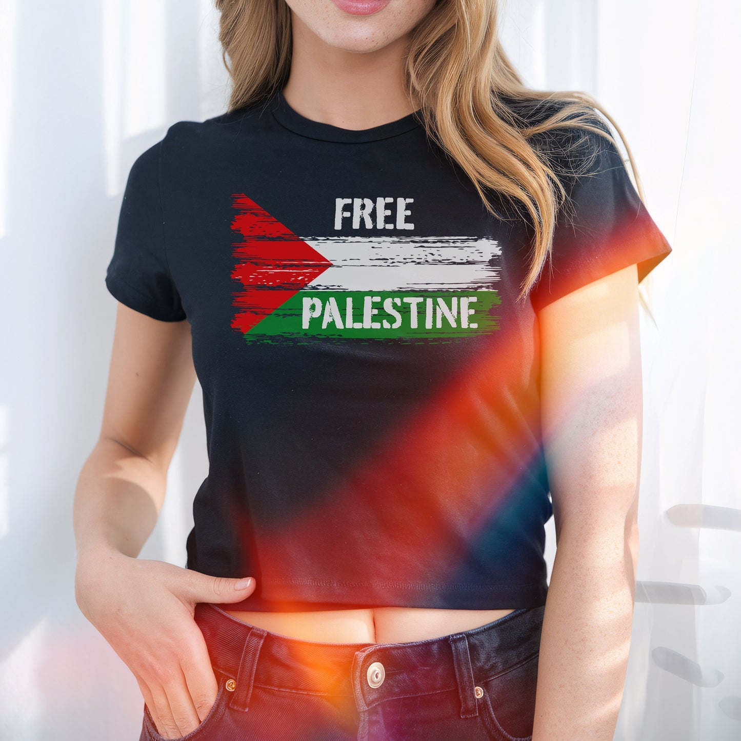 Free Palestine Women's Baby Tee showcasing a stylized Palestinian flag and “FREE PALESTINE” text, worn by a person with one hand in their jeans pocket, embodying bold activism and retro style.
