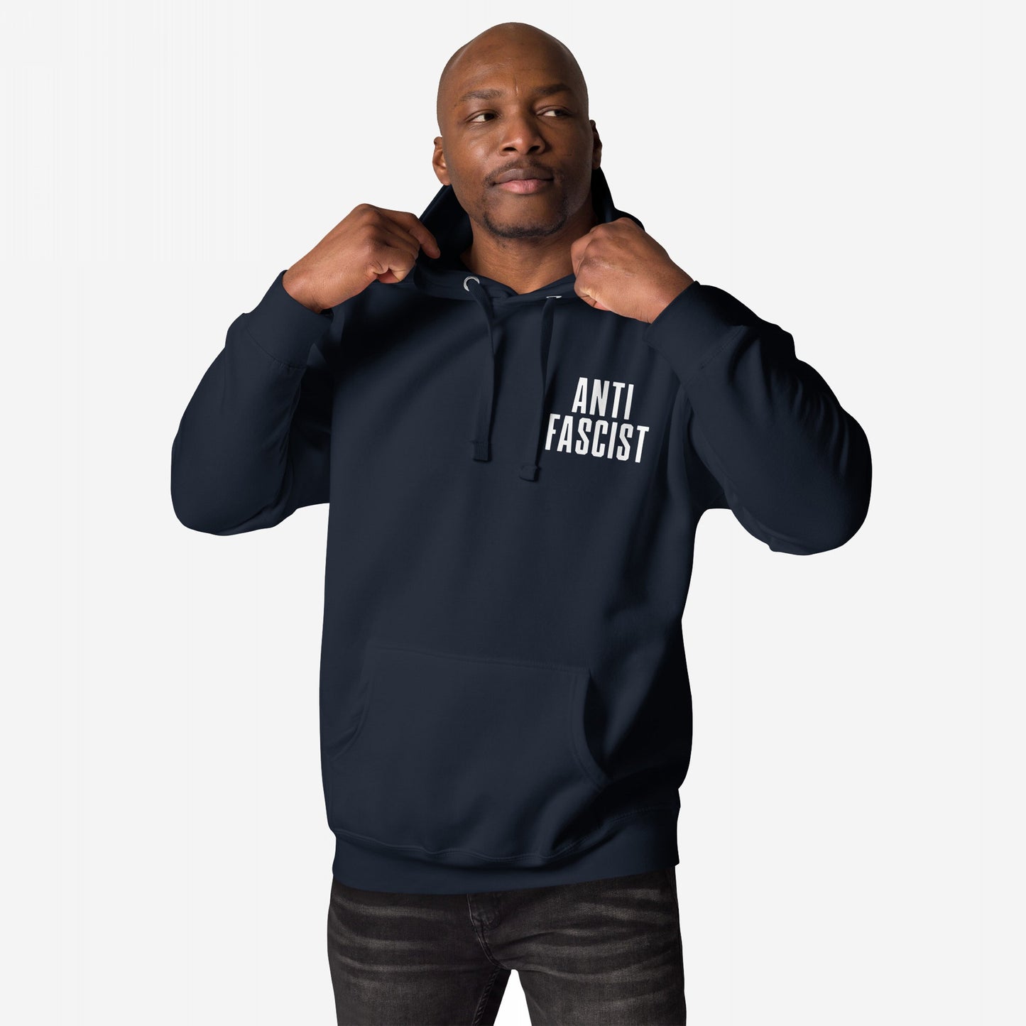 Man in a Fuck 'Em All Back Print Hoodie & Sweatshirt adjusts hood, showcasing ANTI FASCIST in bold. This statement piece embodies zero tolerance for hate and oppression.
