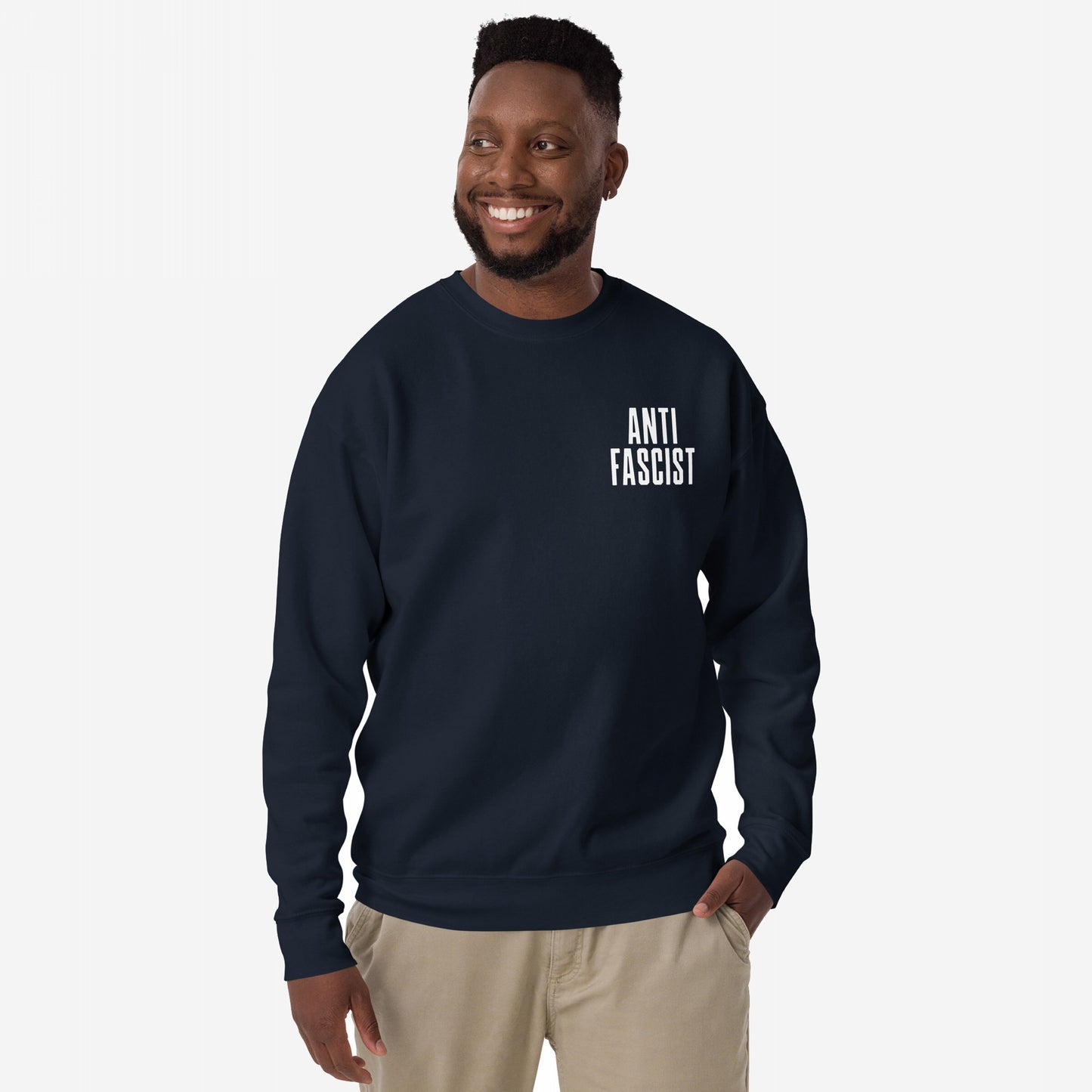 Fuck 'Em All Back Print Hoodie & Sweatshirt features a bold “ANTI FASCIST” print on the chest, worn by a smiling man in light pants, embodying defiance and zero tolerance for oppression.
