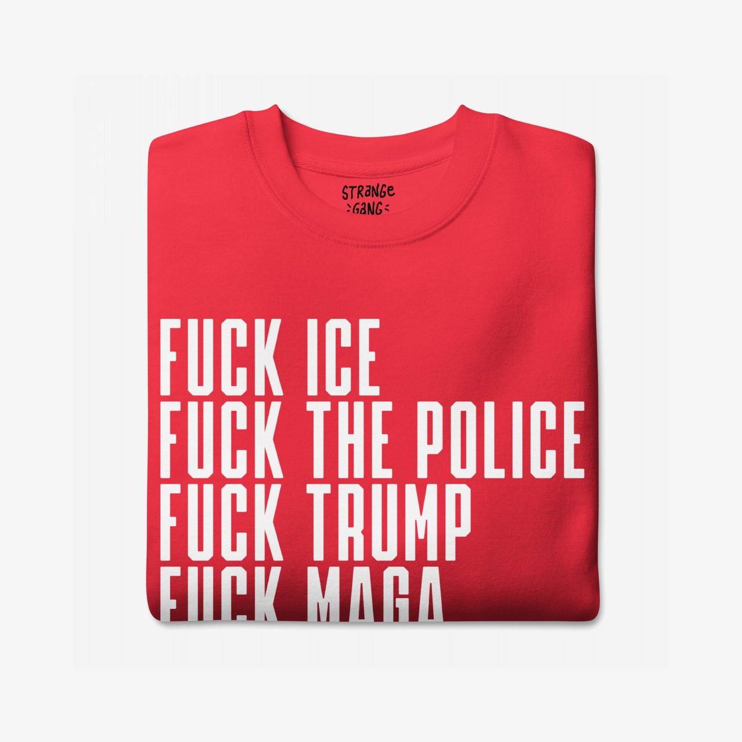 Fuck 'Em All Sweatshirt features bold, white block text denouncing ICE, the police, Trump, and MAGA. A folded, bright-red garment with a collar label visible, embodying defiant protest spirit.