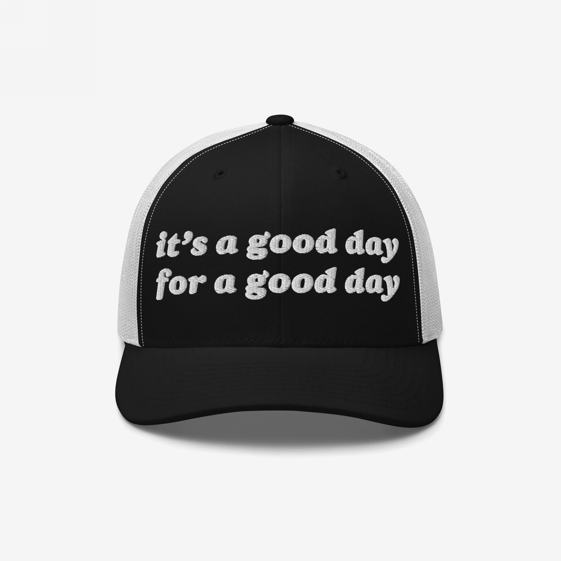 The Good Day Hat features a black front panel with it's a good day for a good day embroidered in white, complemented by a white mesh back, embodying positivity and retro style.