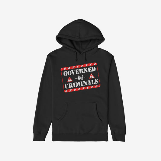Black hoodie titled Governed By Criminals features a distressed red-and-white warning-tape style graphic and warning triangles, symbolizing political dissent and rebellion. Includes a front kangaroo pocket and drawstring hood.
