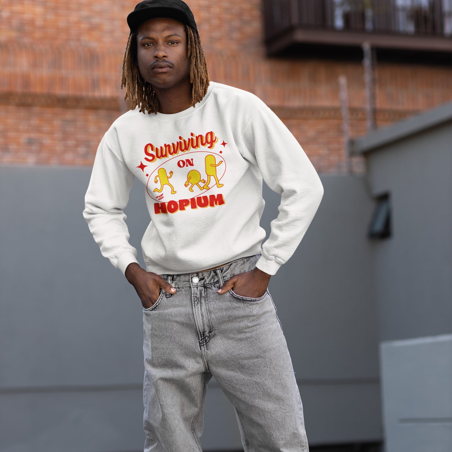 Young woman wearing the Hopium Hoodie & Sweatshirt, featuring Surviving on Hopium graphic with cartoon figures, embodying hopeful optimism. Paired with ripped jeans, perfect for dreamers and reality avoiders.