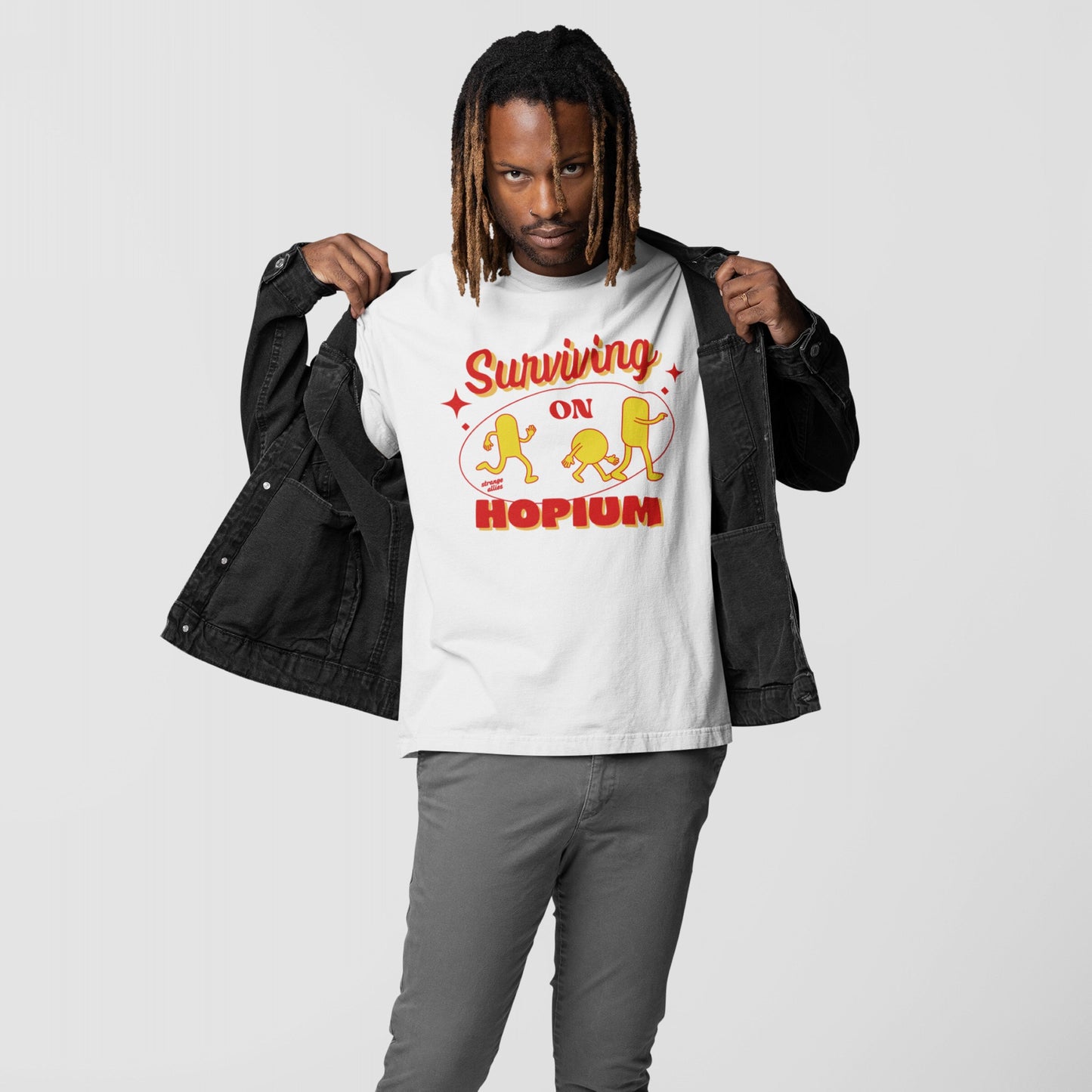Man showcasing Hopium T-shirt, featuring retro Surviving on Hopium graphic with vibrant yellow hop characters. A statement piece for resilient optimists, embodying defiant spirit and unwavering hope. Available in various styles and sizes.