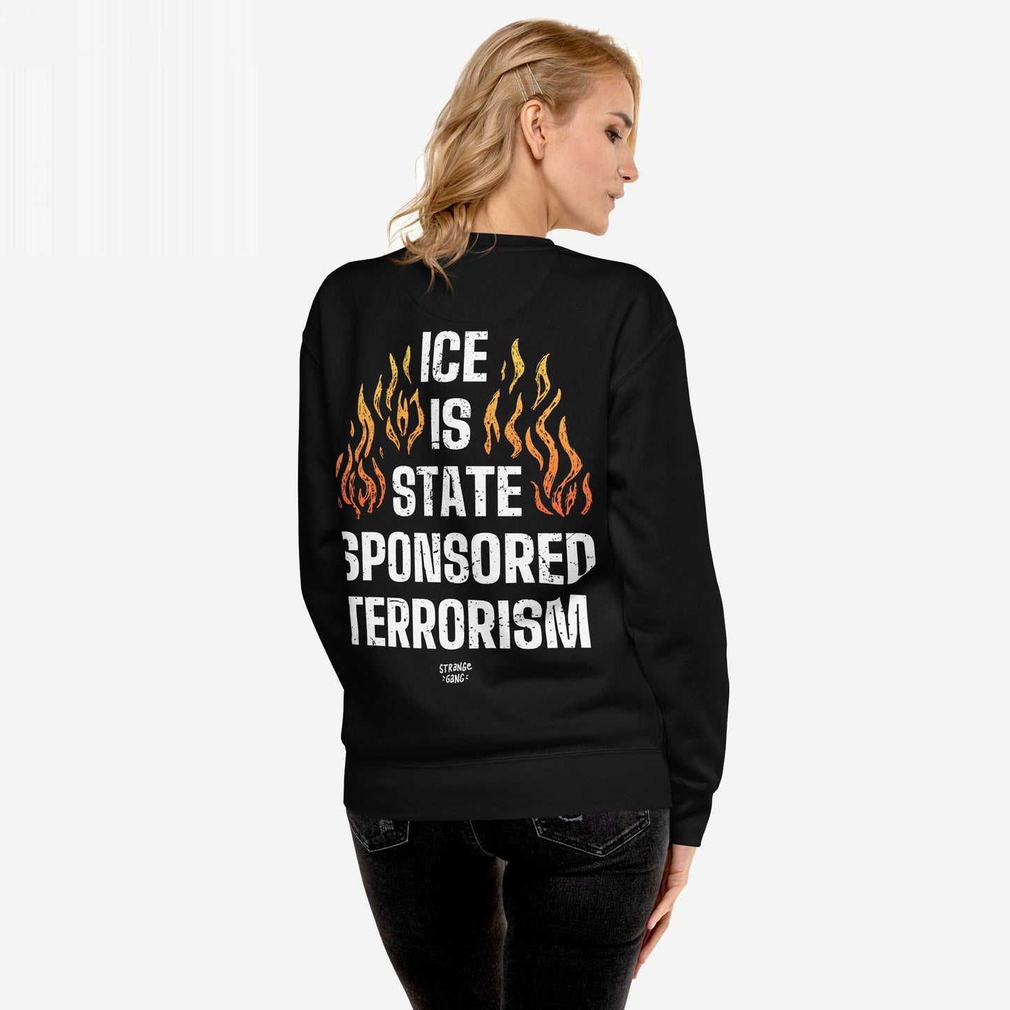 Back view of ICE Is State Sponsored Terrorism Hoodie & Sweatshirt, showcasing bold white lettering and stylized flames, worn by a person with pinned-back shoulder-length blonde hair against a plain white background.