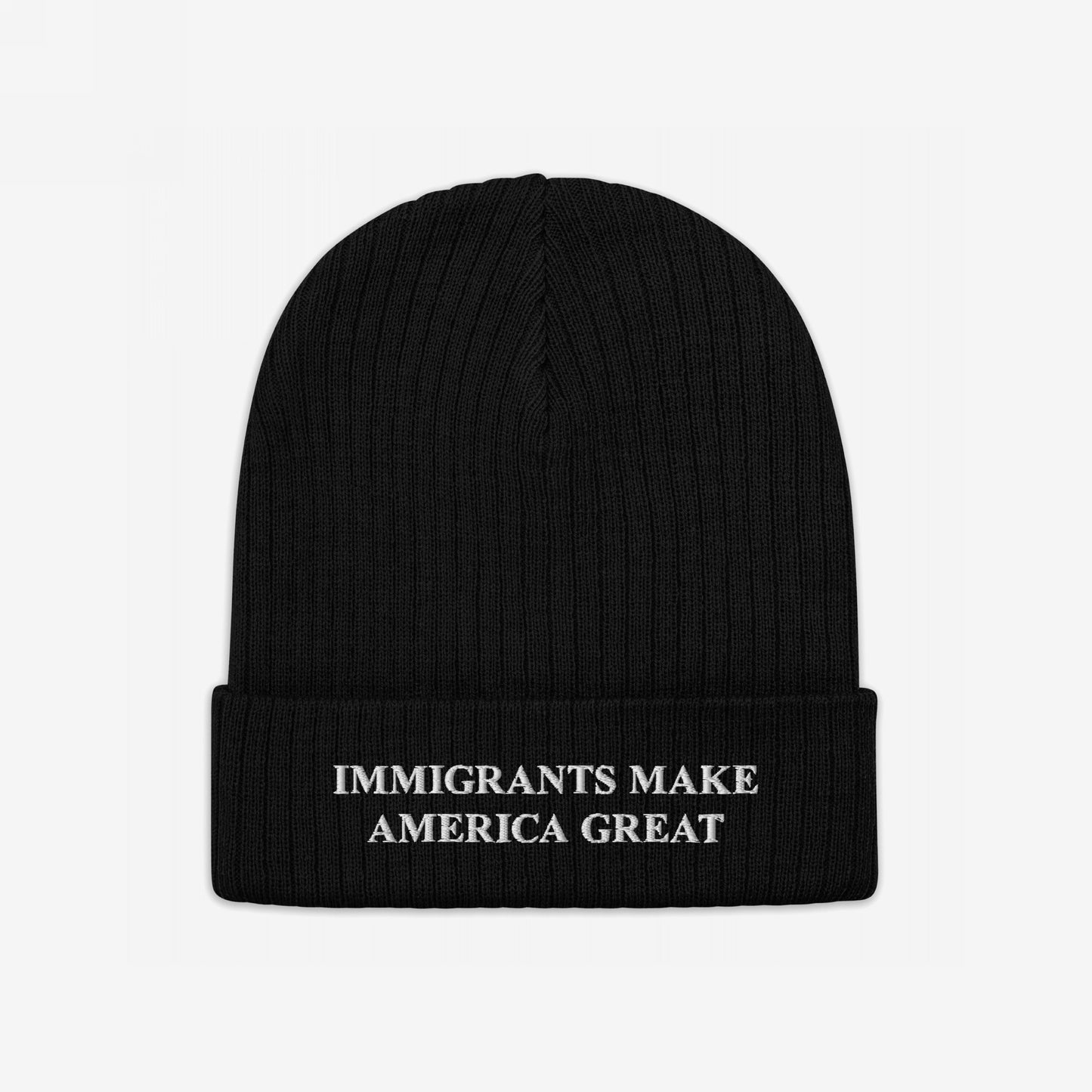 Black rib-knit beanie titled Immigrants Make America Great Hat with bold white embroidery on the cuff. A statement piece advocating for immigrant rights, perfect for rallies or daily wear.
