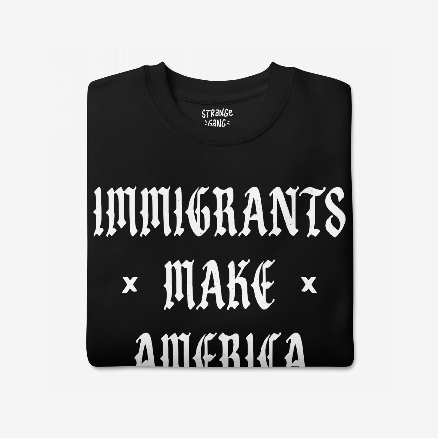 Immigrants Make America Great Sweatshirt featuring bold white Old English lettering on a black fabric, symbolizing immigrant pride and resistance. Small brand logo visible at the neckline.
