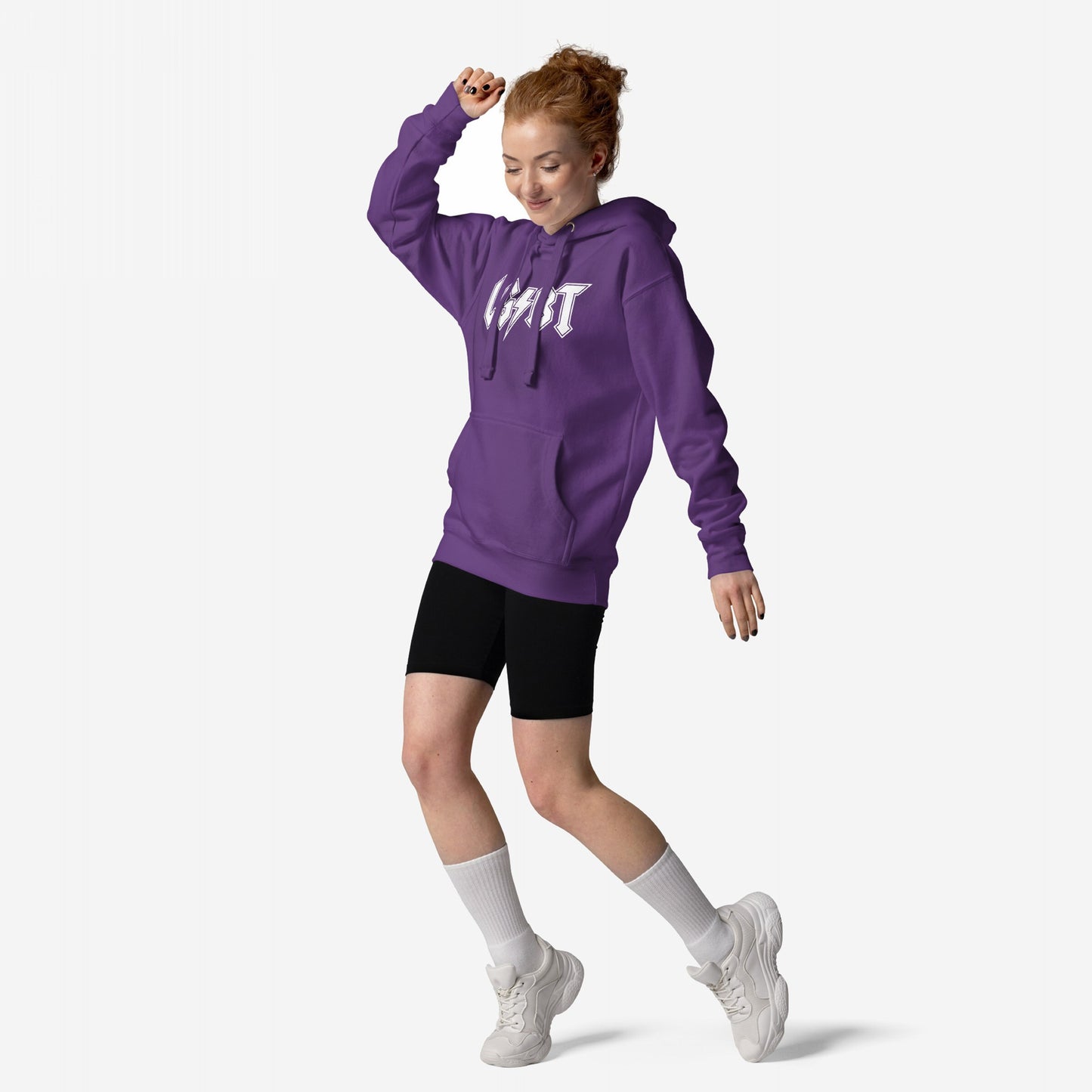 Young woman energetically poses in a purple LGBTQ Rocks Hoodie with LIGHT graphic, paired with black bike shorts, showcasing pride and resilience.