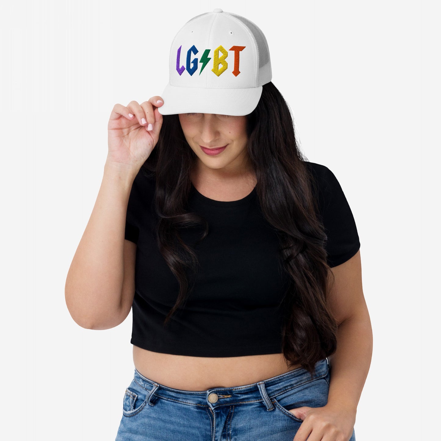Woman wearing a white LGBTQ Rocks Hat with rainbow embroidery and lightning bolt, styled with a black crop top and blue jeans.