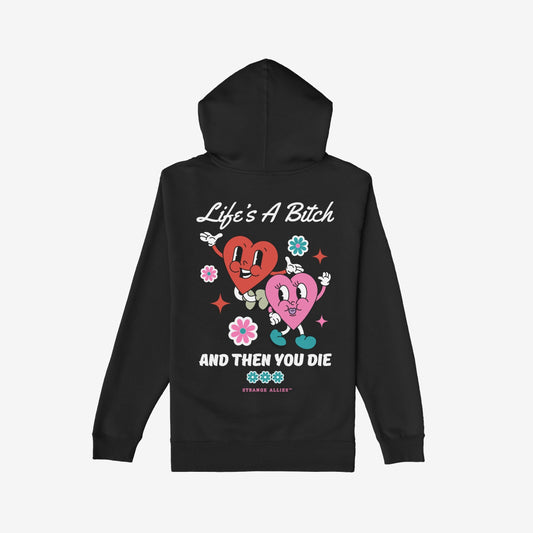 Life's A Bitch Shirt featuring retro-cartoon design with cheerful, dancing hearts and bold slogans, capturing a candid, unapologetic message against a backdrop of whimsical flowers and stars.
