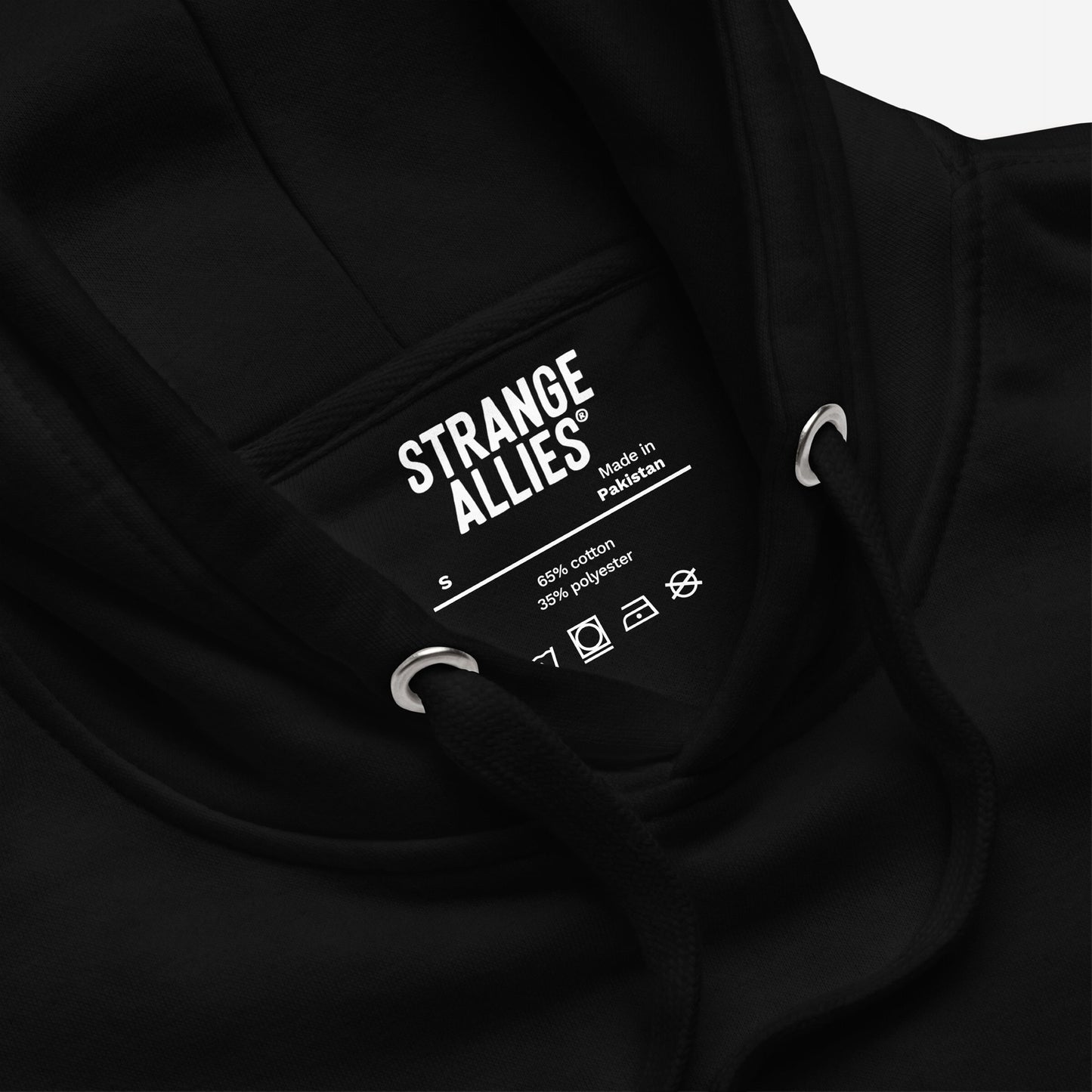 Close-up of the Life's A Bitch Hoodie & Sweatshirt, showcasing the neck label with brand STRANGE ALLIES, size S, and care icons. Highlighting soft fleece for unfiltered realism.
