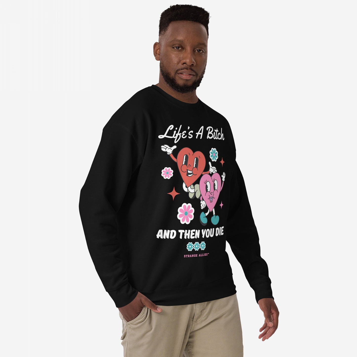 Life's A Bitch Hoodie & Sweatshirt featuring retro-cartoon hearts and flowers with a bold slogan, worn by a male model. Perfect for those embracing stark honesty and comfort.