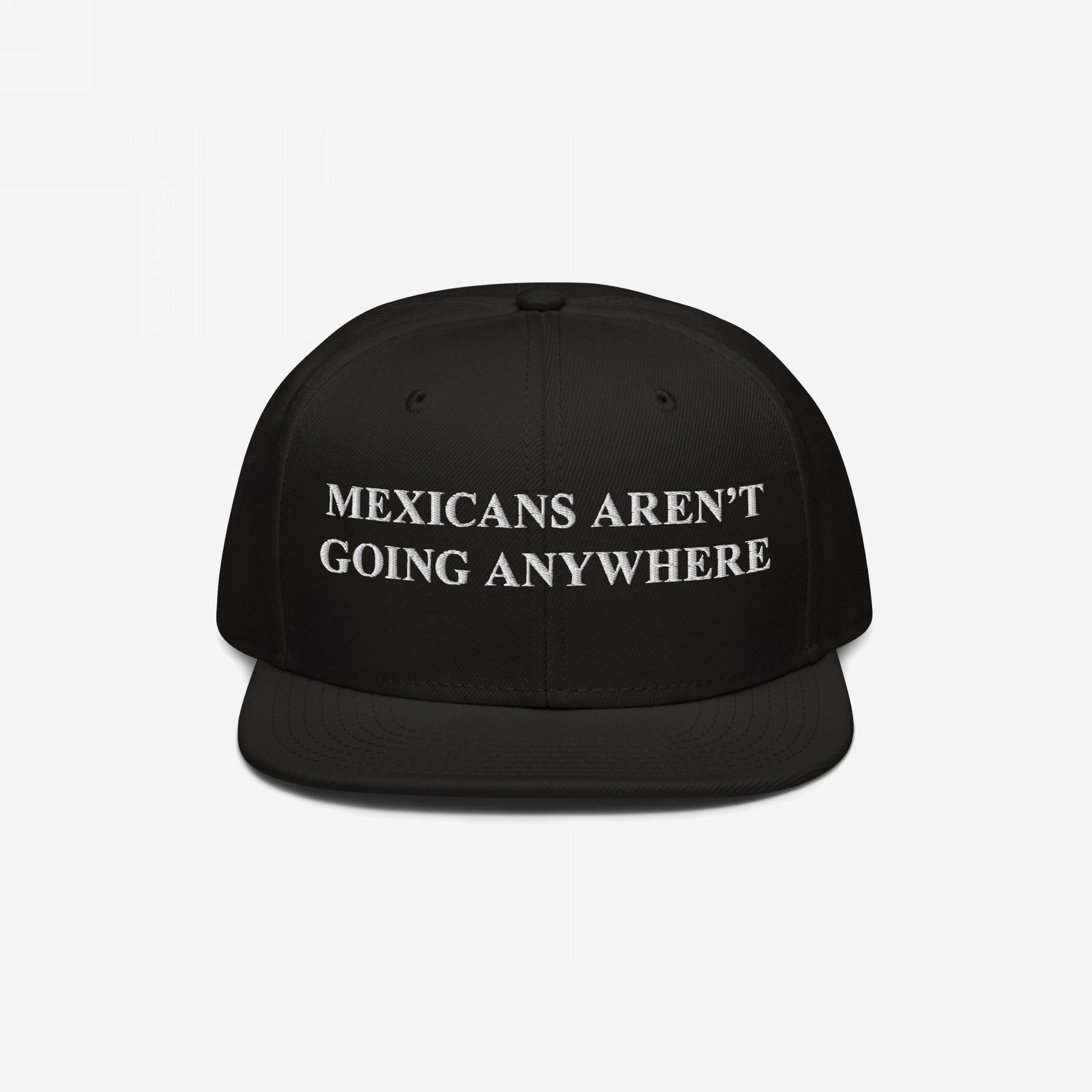 Black snapback hat featuring bold white embroidery reading “Mexicans Aren’t Going Anywhere,” symbolizing pride and resistance against racism and anti-immigrant sentiments, aligned with empowering social justice messaging.