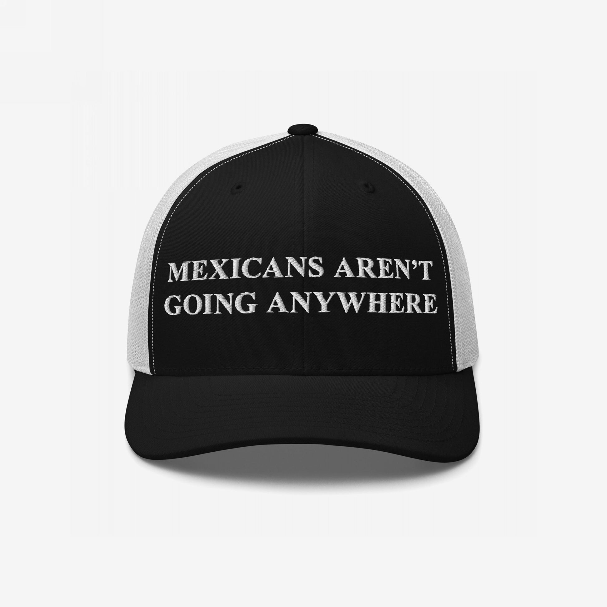 Mexicans Aren’t Going Anywhere Hat: A black-and-white trucker hat with bold white embroidery, expressing pride and resistance against racism and nationalism, supporting the Immigrant Legal Resource Center.