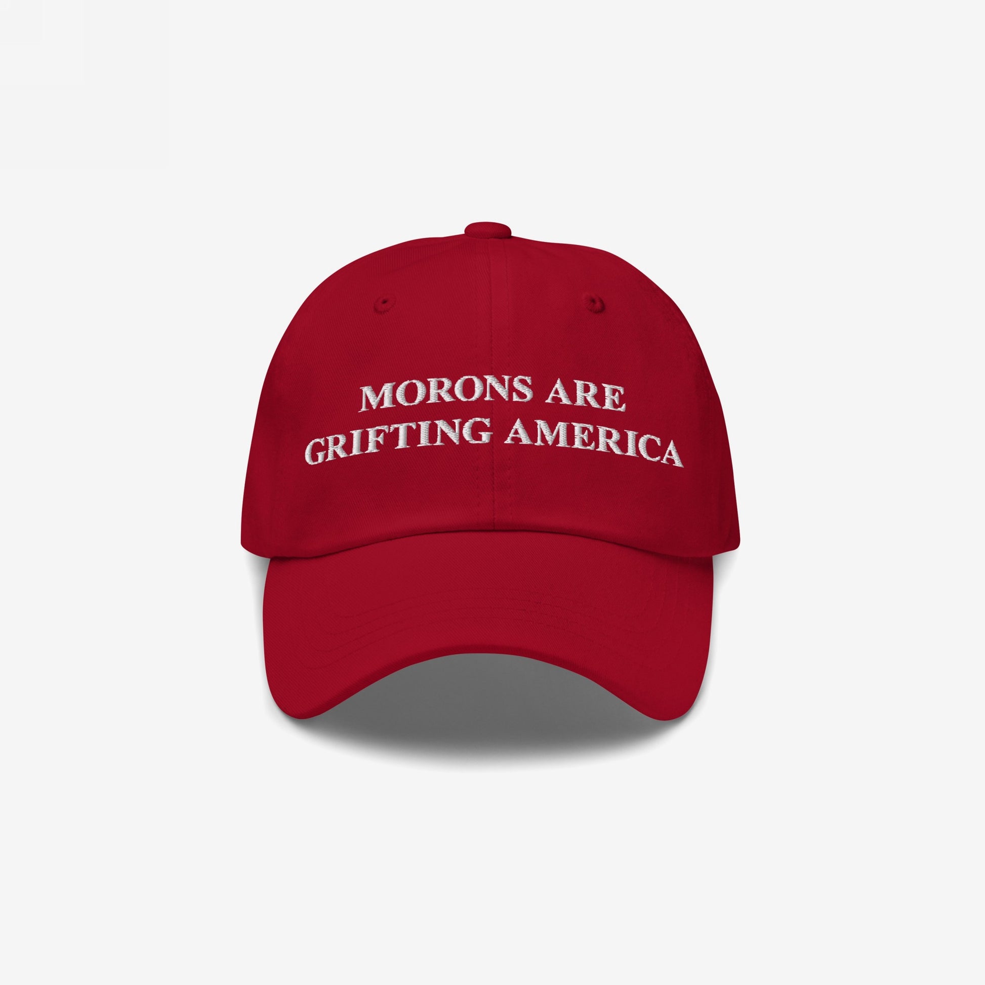 Red dad hat styled to mimic MAGA caps but flipped with embroidered white text "Morons Are Grifting America" — a direct anti-MAGA statement in their own colorway.