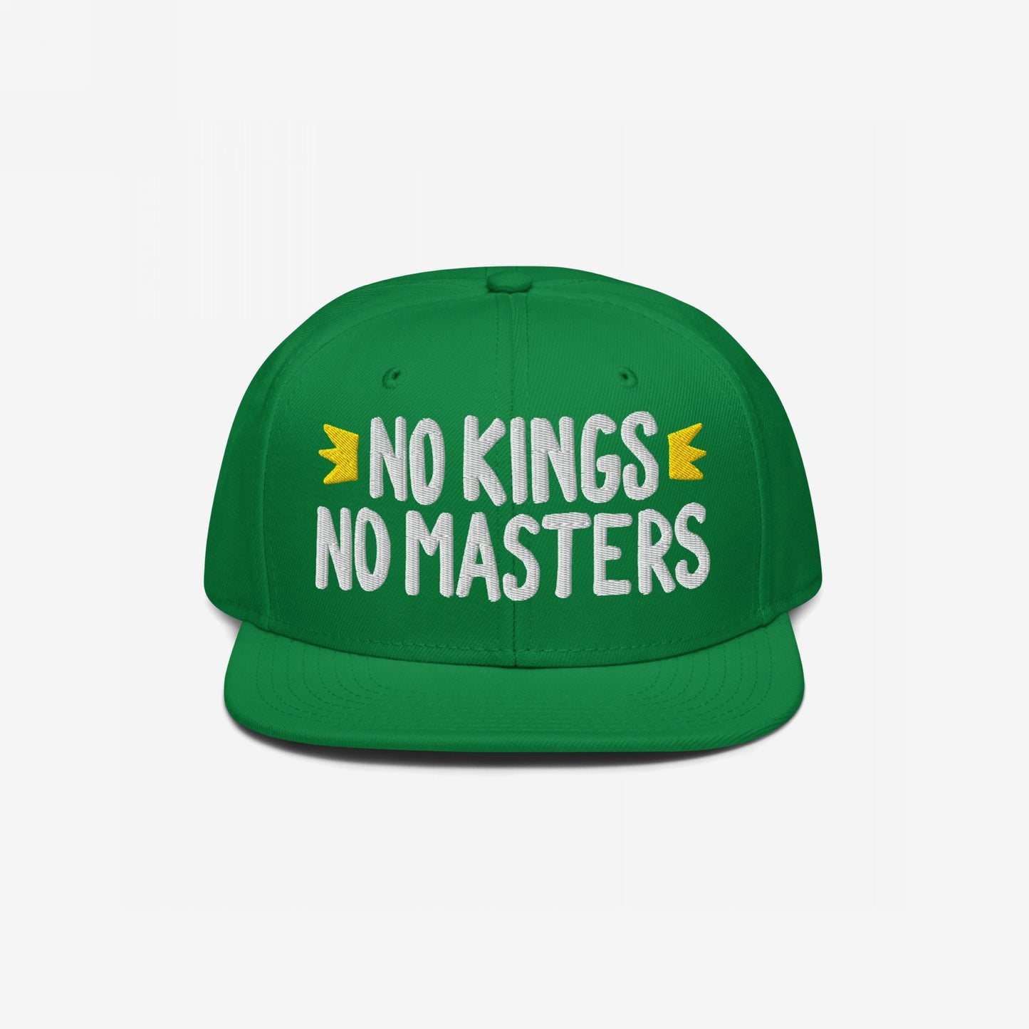 The No Kings No Masters Hat features white embroidered text and yellow crown accents on a green snapback, embodying rebellious spirit and style.